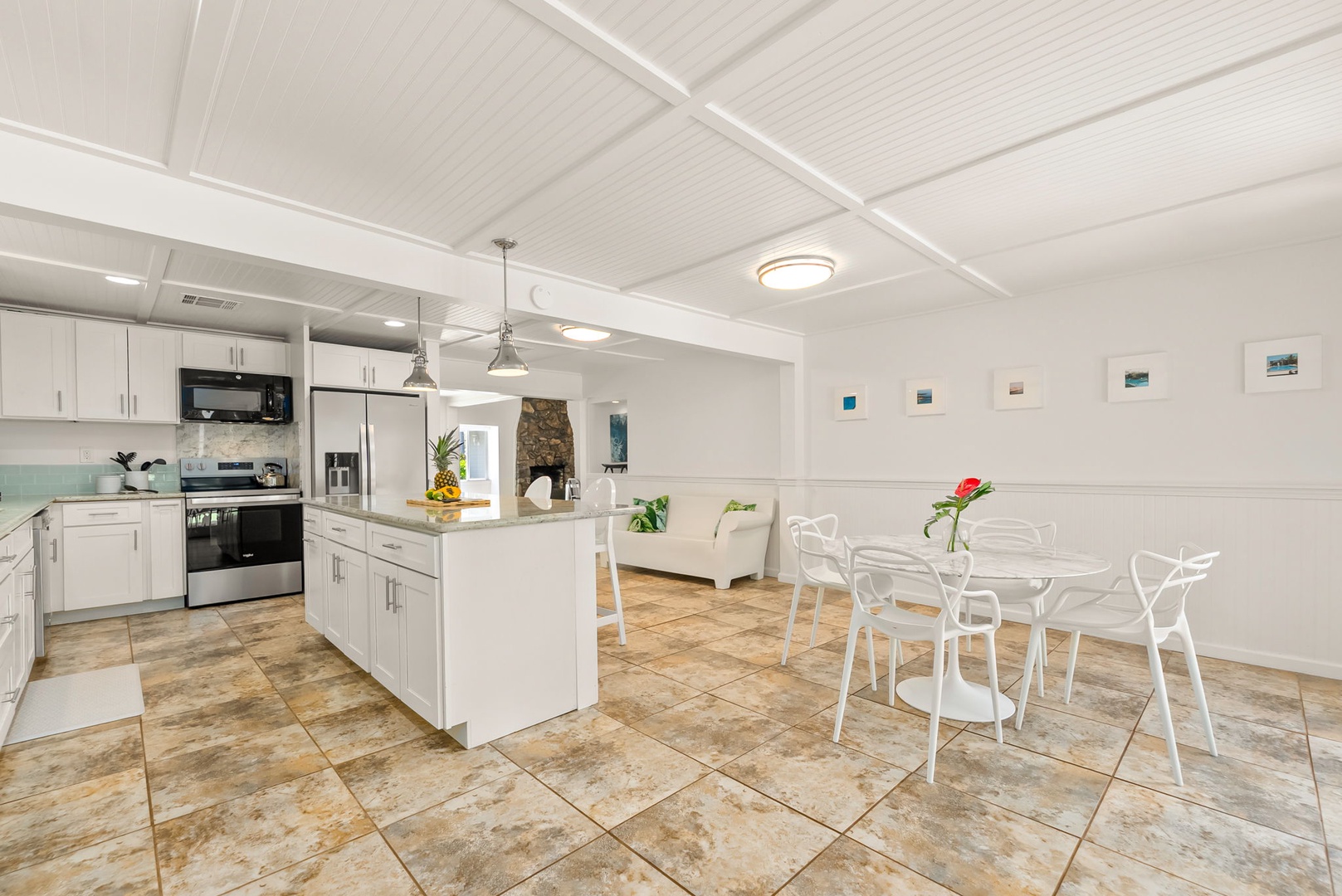 Honolulu Vacation Rentals, Ho'okipa Villa - Your open-concept kitchen and dining space features modern stainless-steel appliances, bright white cabinetry, and a welcoming island perfect for meal prep and casual gatherings.