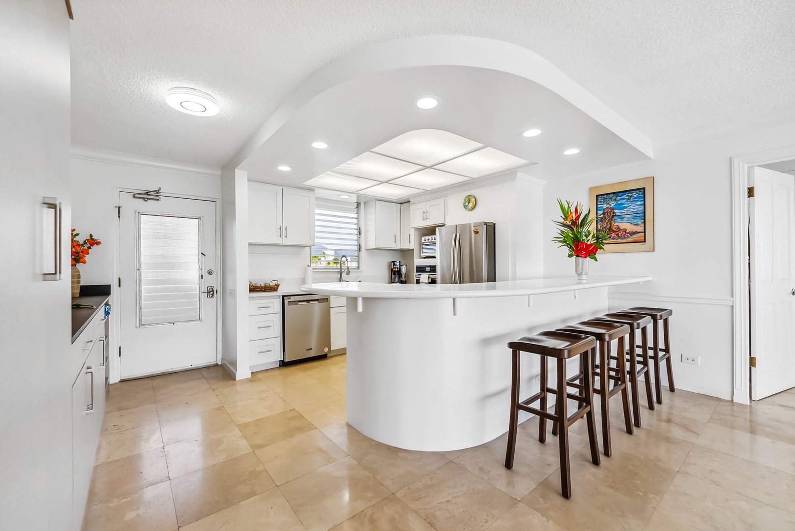 Honolulu Vacation Rentals, Colony Surf Getaway - Bright, open kitchen with bar seating, modern appliances, and plenty of counter space—perfect for cooking and gathering.