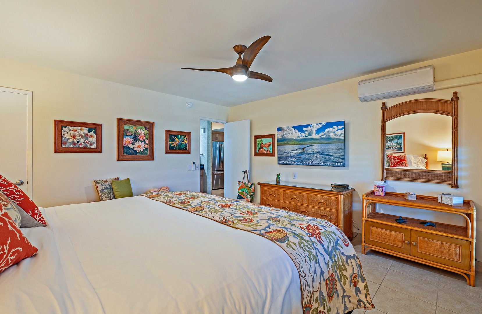 Lahaina Vacation Rentals, Kahana Sunset B4B - The bedroom features tropical artwork, a cozy bed with colorful bedding, and ample storage space, making it comfortable.