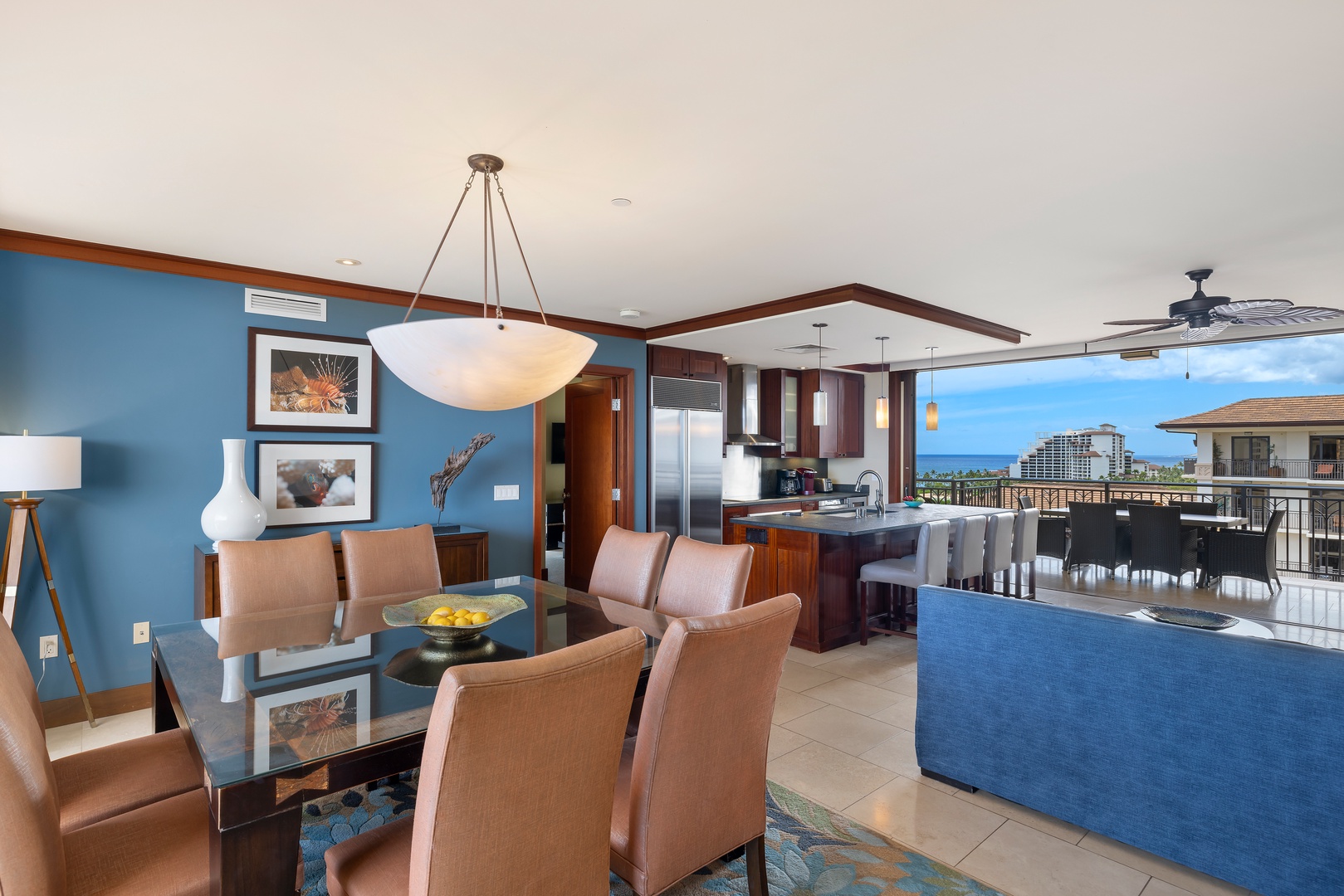 Relax in your stylish open-plan living space with stunning ocean views through floor-to-ceiling windows and elegant modern furnishings.