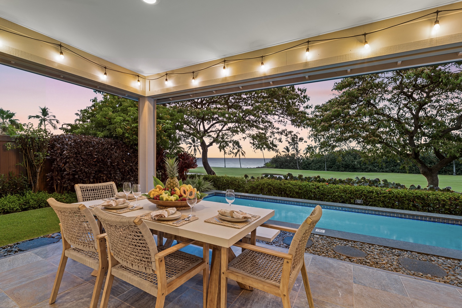 Kailua Kona Vacation Rentals, Holua Kai #27 - A set table under the lanai lights is where dinner runs long.