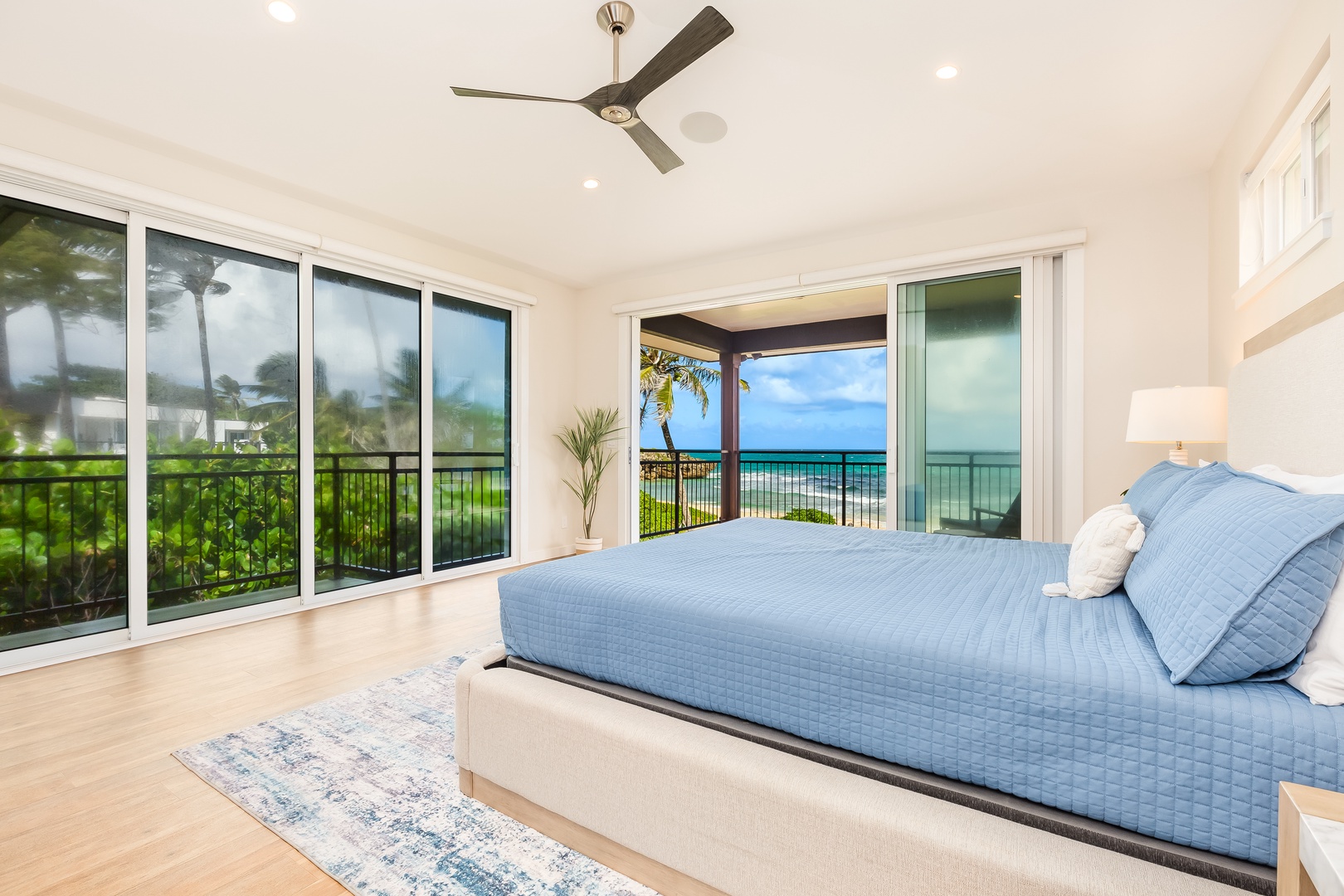 Laie Vacation Rentals, Majestic Mahakea Oceanfront Oasis - Spacious primary bedroom with large windows showcasing sweeping views of the coastline.