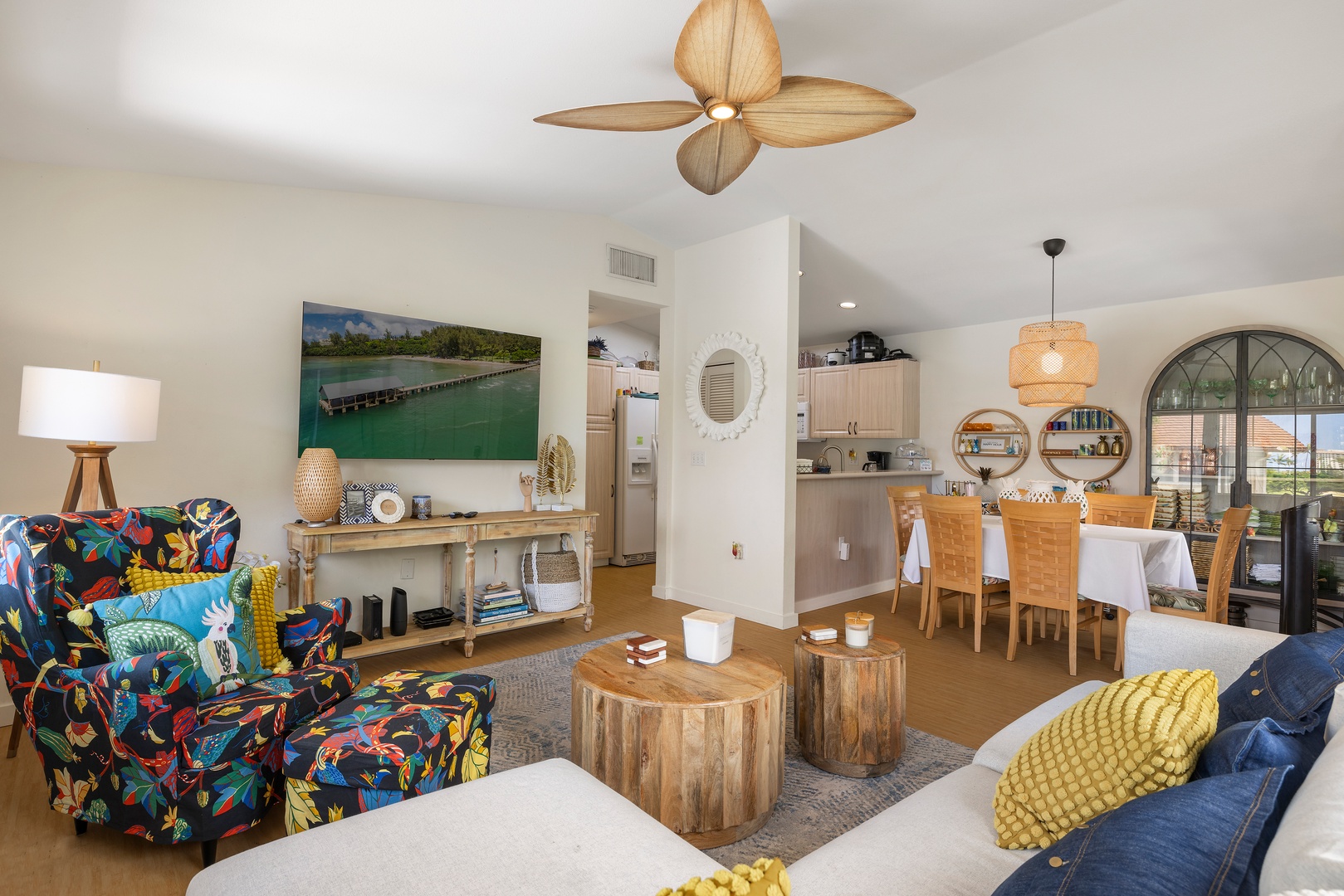 Unwind in your bright open-plan living space where tropical vibes meet modern comfort, featuring colorful furnishings and ocean-inspired art.