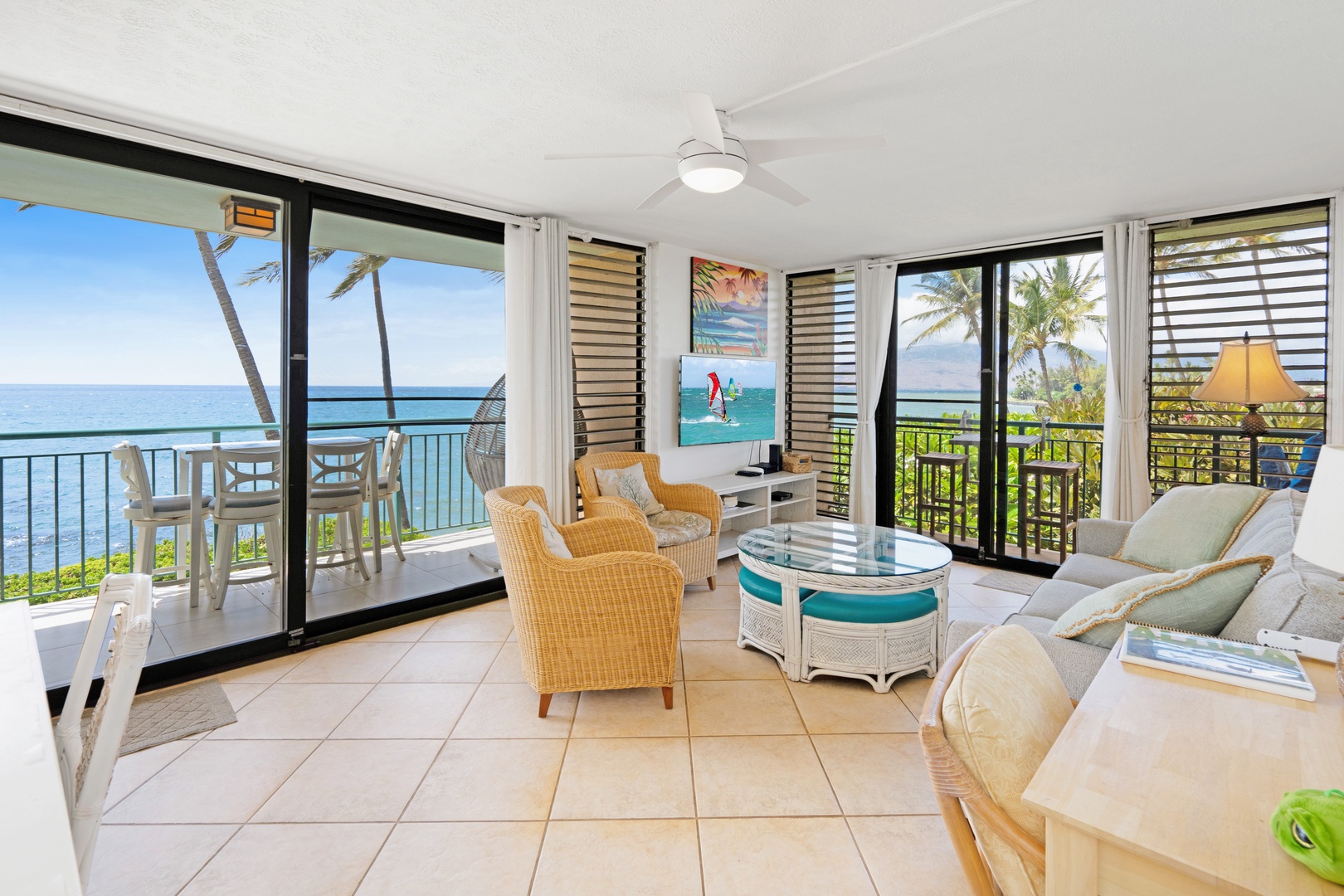 Kihei Vacation Rentals, Punahoa Beach 205 - Wicker armchairs face the balcony doors, ocean and sky filling the frame beyond.