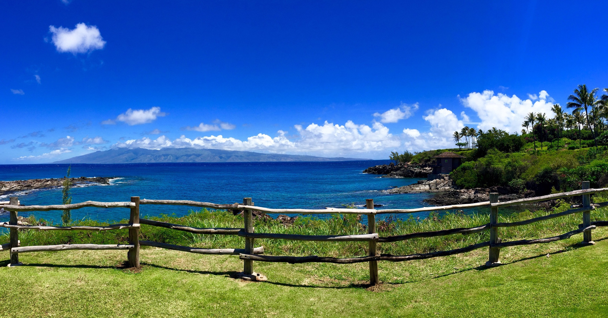 Lahaina Vacation Rentals, Kapalua Ridge 1421 - A stunning coastal view framed by a rustic wooden fence, overlooking the crystal blue waters and rocky cliffs