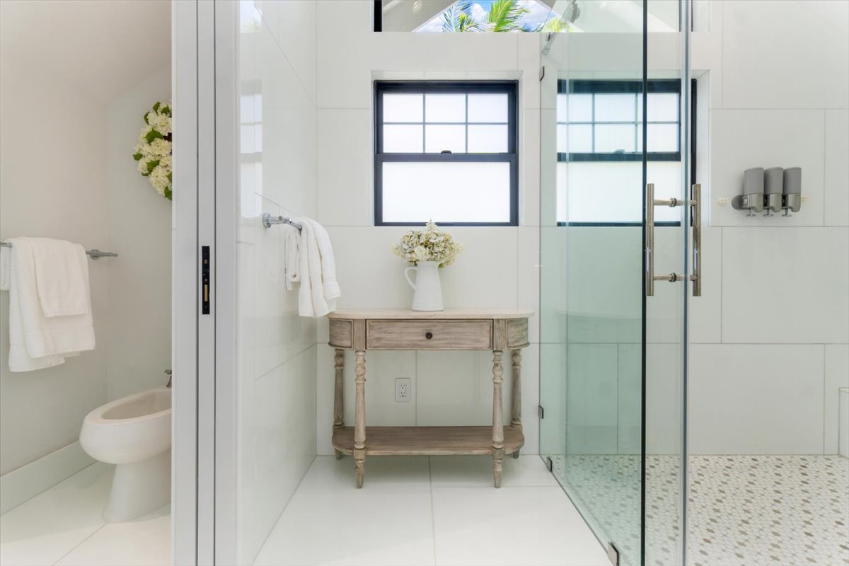Kailua Vacation Rentals, Kailua Beachfront Estate - Spa-like guest bathroom with rainfall shower, stone accents, and garden view.