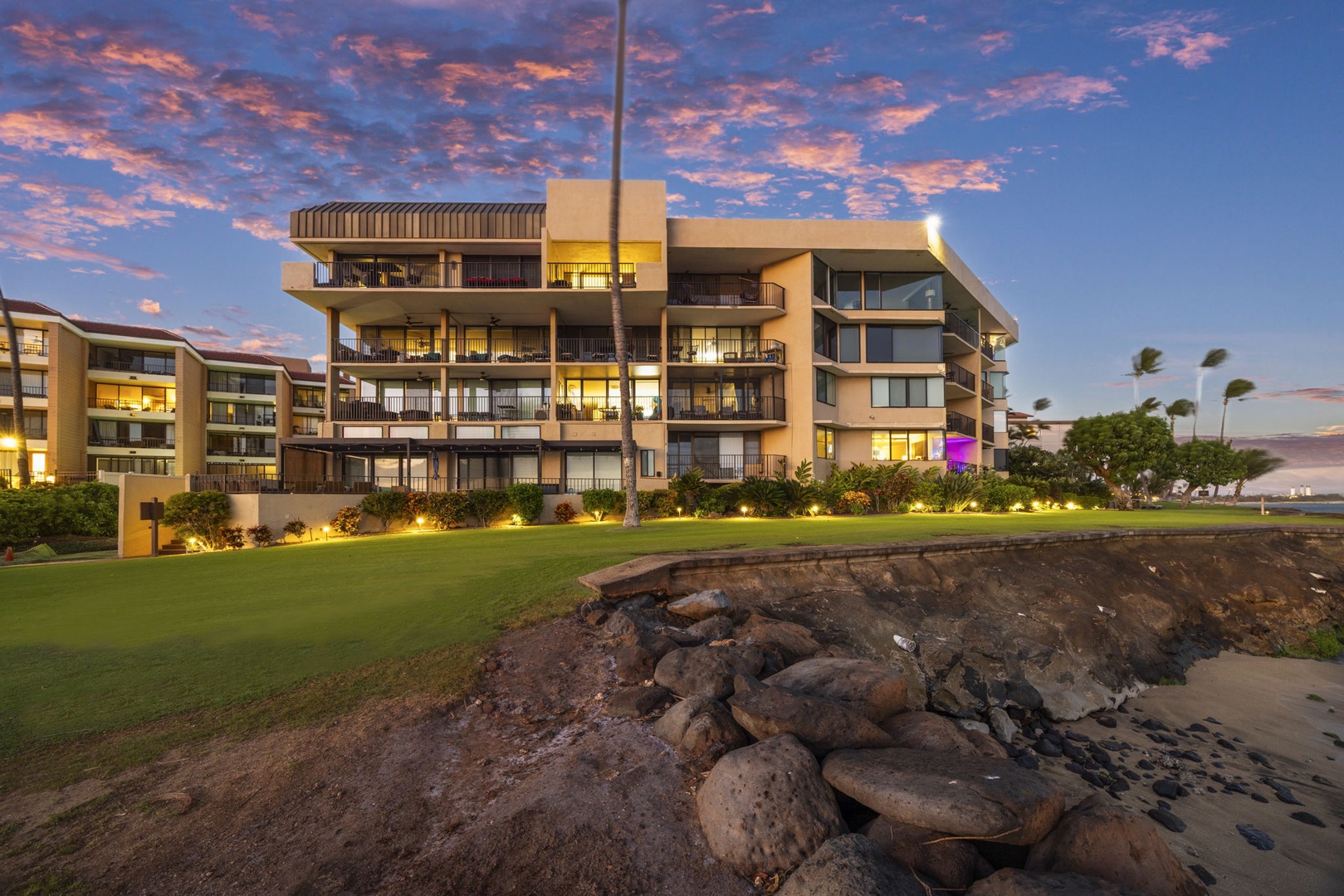 Wailuku Vacation Rentals, Milowai 310 - Evening settles over the lawn and seawall, lanais glowing above and facing straight out to sea.