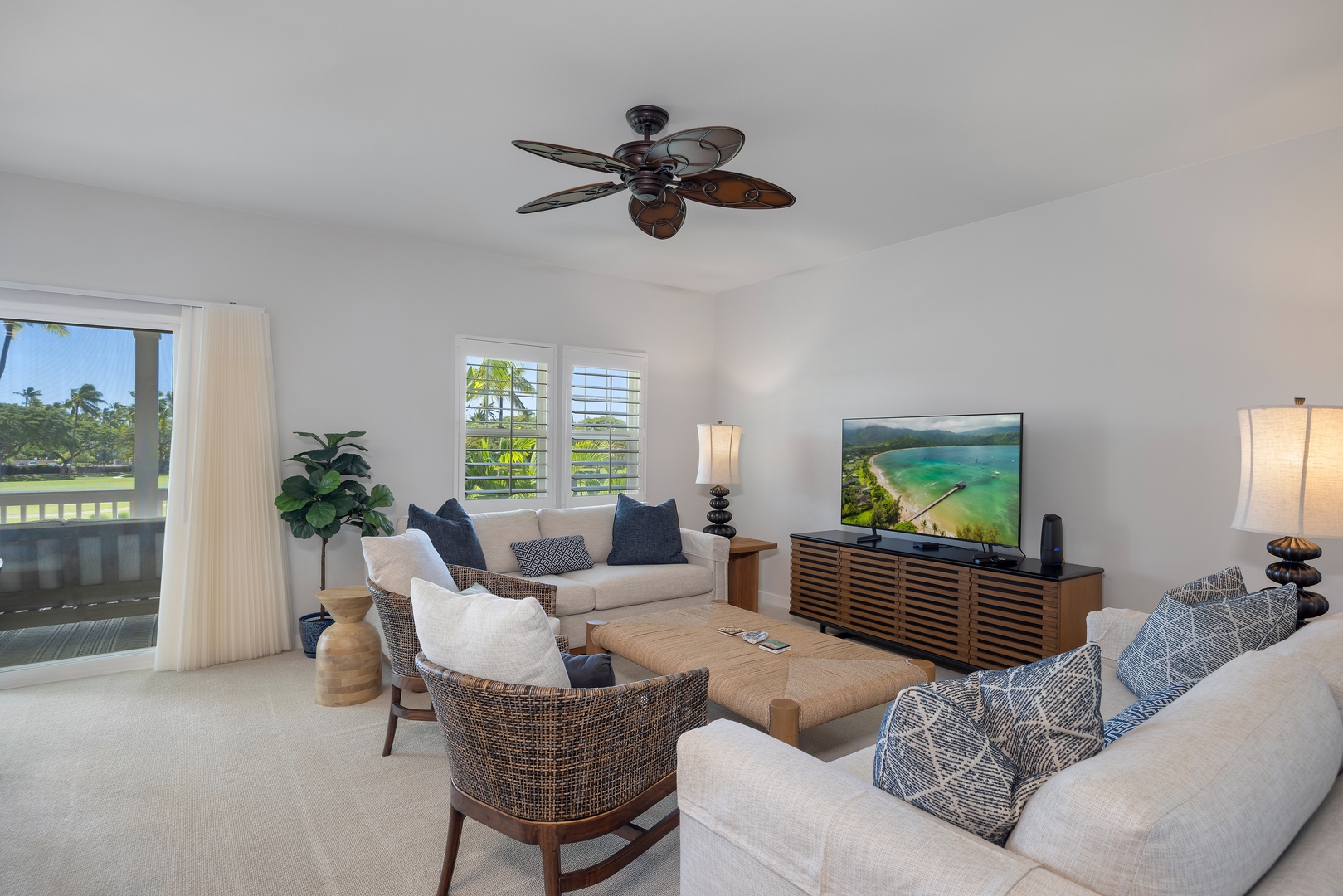 Unwind in your spacious living room featuring tropical-inspired décor, plush seating, and a large smart TV for cozy evenings together.