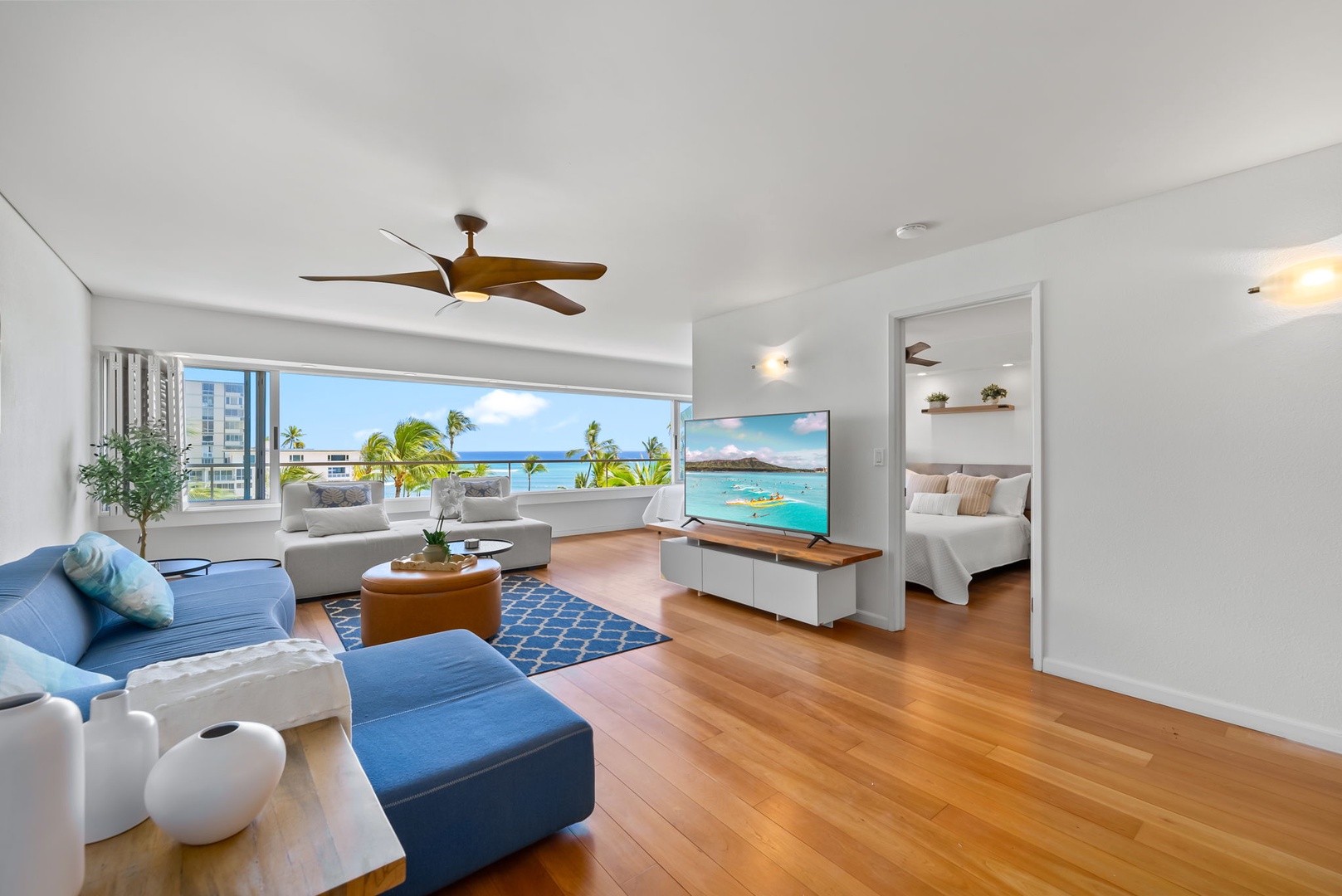 Honolulu Vacation Rentals, Colony Surf Retreat - Relaxation meets oceanfront luxury in the main living space, featuring a full-size sleeper sofa and scenic backdrop.