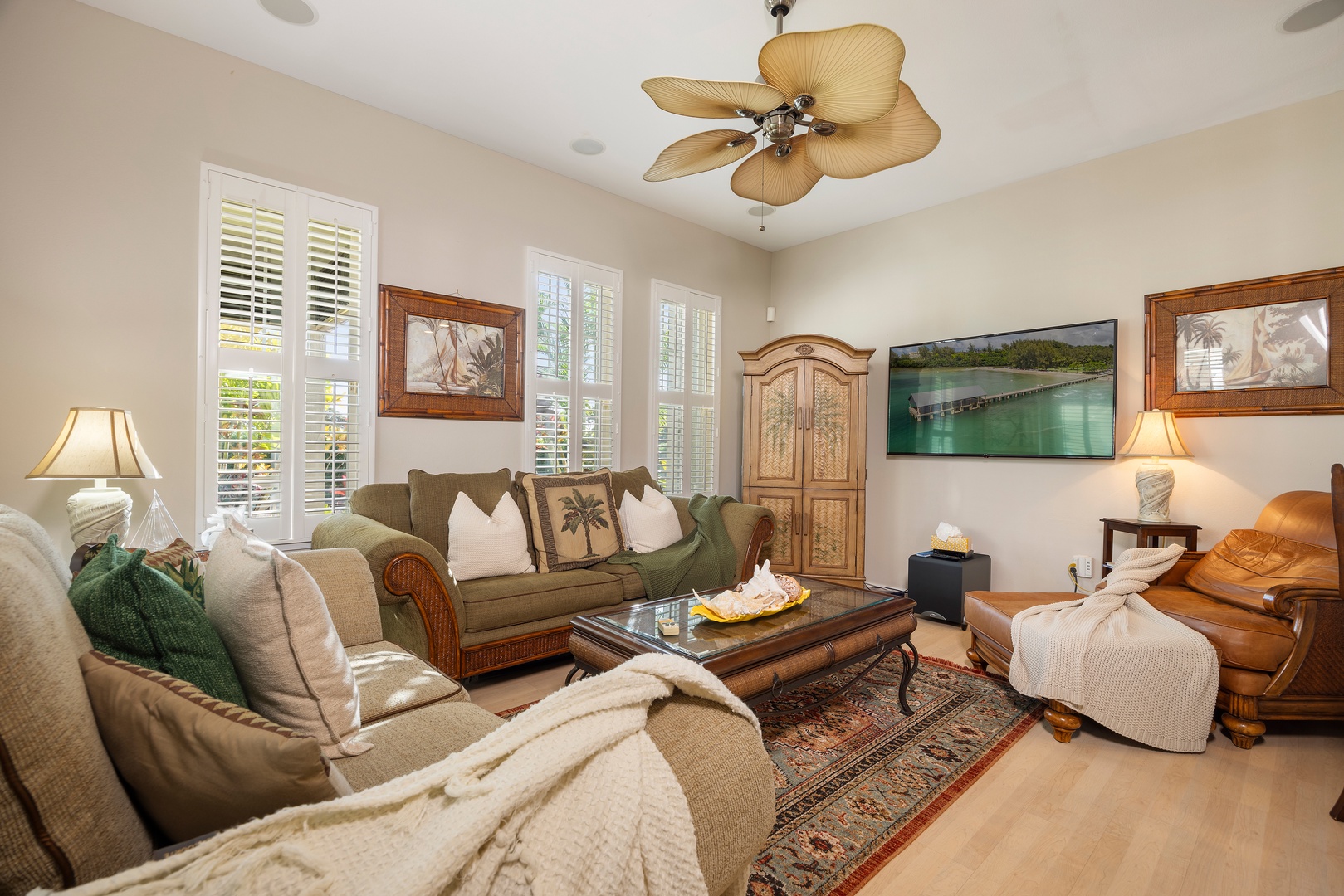 Sink into plush seating surrounded by tropical touches and coastal artwork. Your peaceful retreat awaits with comfortable furnishings and gentle ceiling fan breeze.