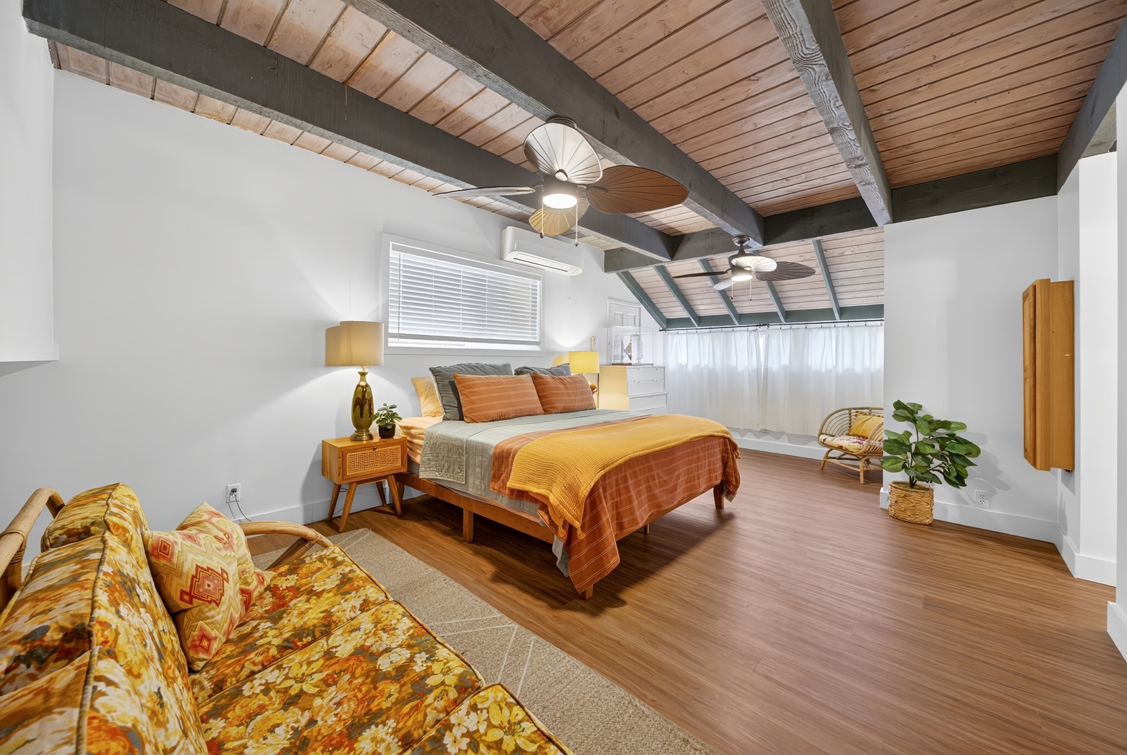 Laie Vacation Rentals, Dolphin House - Your spacious retreat features warm wood tones, exposed beams, and a cozy seating area beneath vaulted ceilings—perfect for unwinding after a day of adventure.