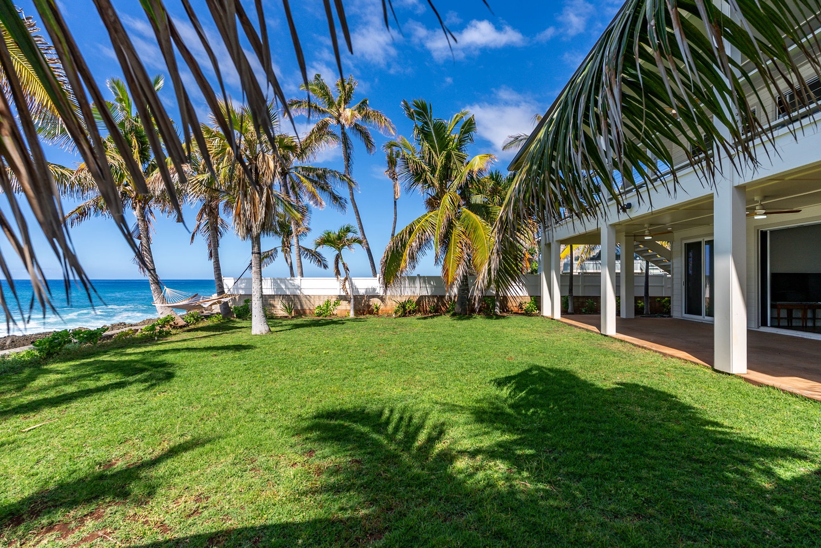 Waianae Vacation Rentals, Oceanfront Luxury Dream Estate - Late afternoon shadows stretch across the lawn as swaying trees offer cooling shade and tropical ambiance.
