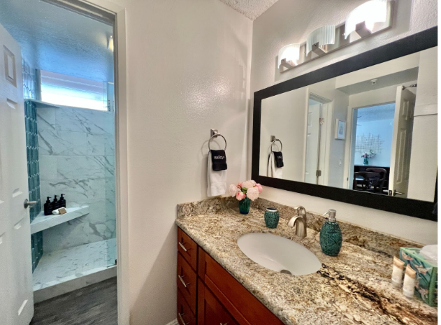 Lahaina Vacation Rentals, Royal Kahana 308 - This elegant bathroom features a spacious granite countertop with a large mirror and modern lighting, providing both style and functionality.