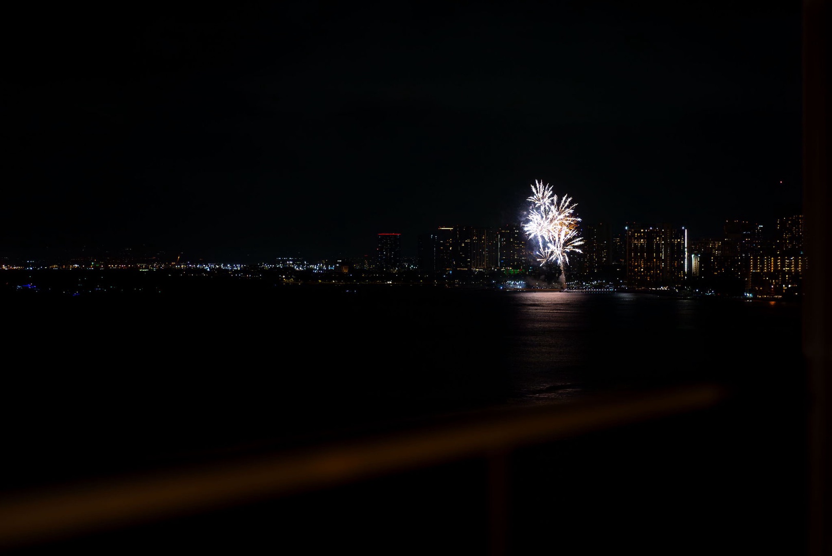 Honolulu Vacation Rentals, Hale Kaimana - Radiant fireworks burst lighting up the night sky and reflecting on the tranquil ocean.