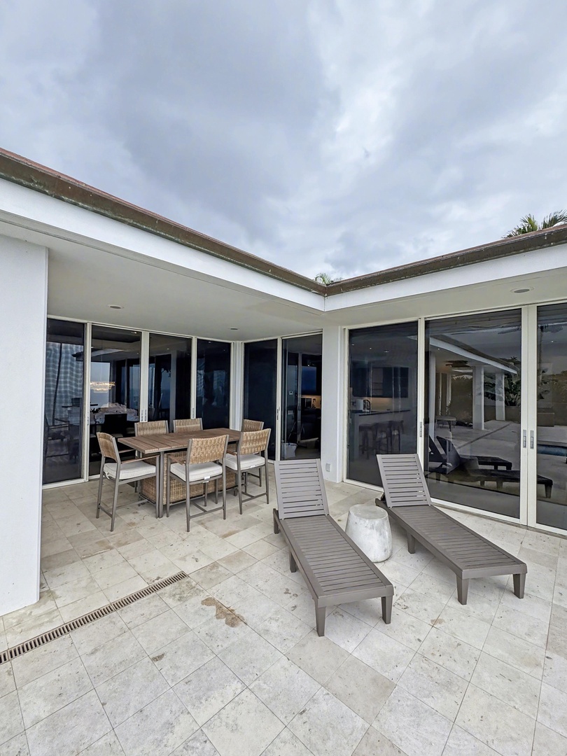 Kailua Kona Vacation Rentals, Hale Nai'a - Your private lanai features elegant outdoor dining and lounging furniture, seamlessly connecting to spacious interiors through floor-to-ceiling windows for perfect indoor-outdoor living.