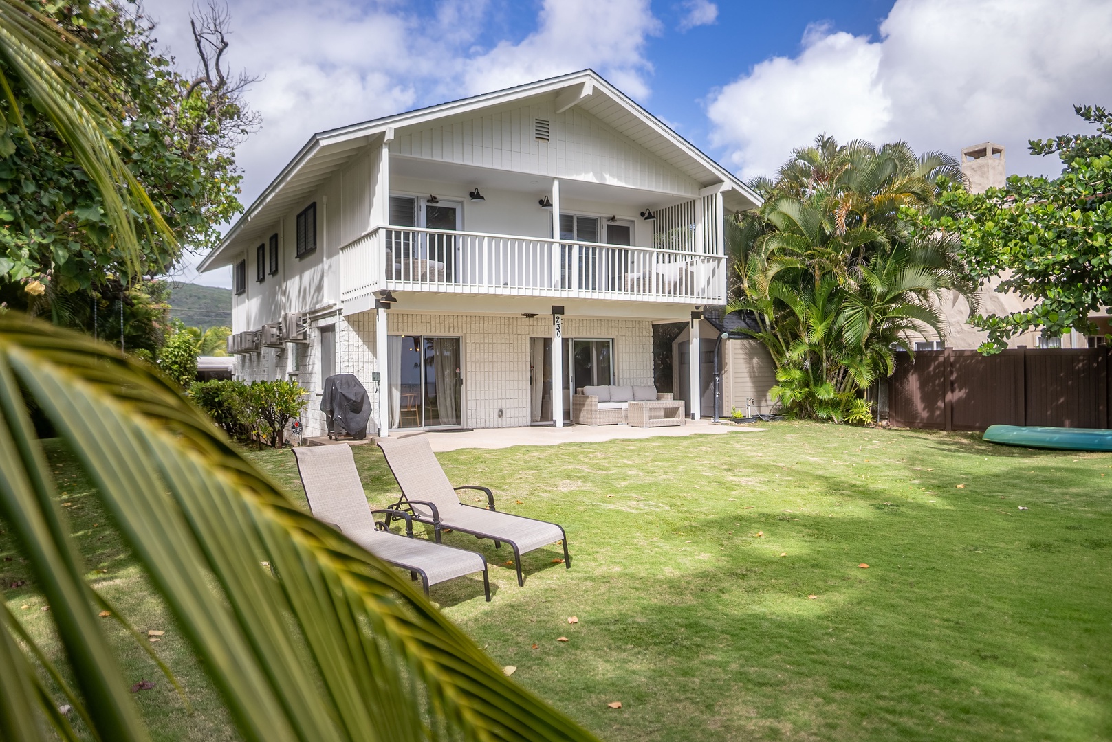Honolulu Vacation Rentals, Honolulu Beachfront Retreat - Charming view of the home from the backyard, with outdoor lounge chairs inviting guests to relax and enjoy sunny days.