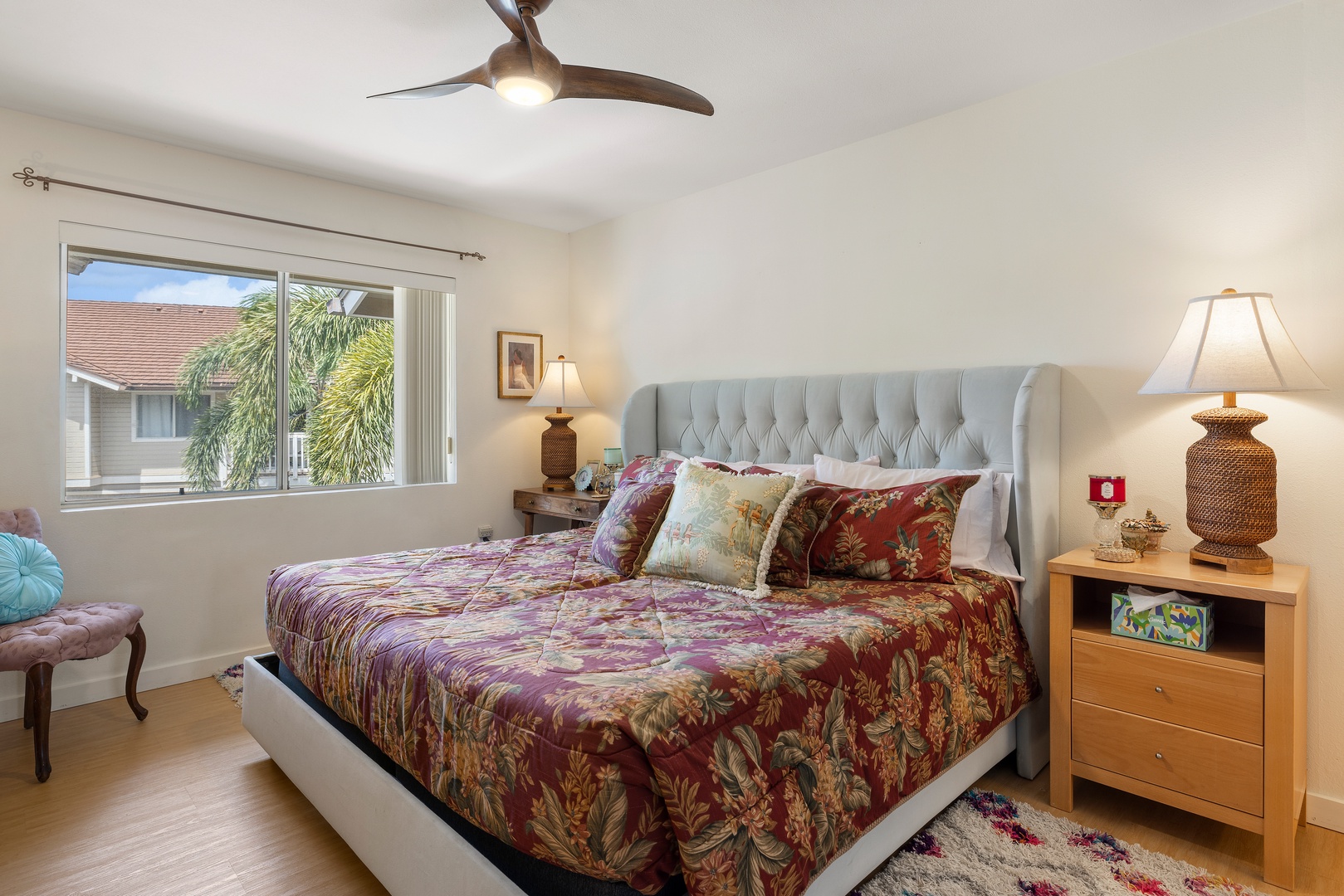 Rest peacefully in your tropical bedroom with tufted headboard, ceiling fan, and palm views through your window.