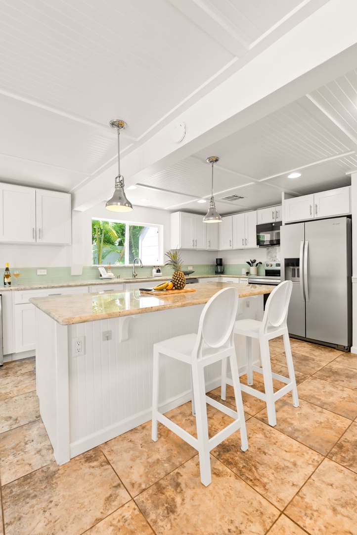 Honolulu Vacation Rentals, Ho'okipa Villa - Gather around the spacious kitchen island with gleaming granite countertops, modern stainless appliances, and bright natural light streaming through the window. Your perfect spot for morning coffee and meal prep.