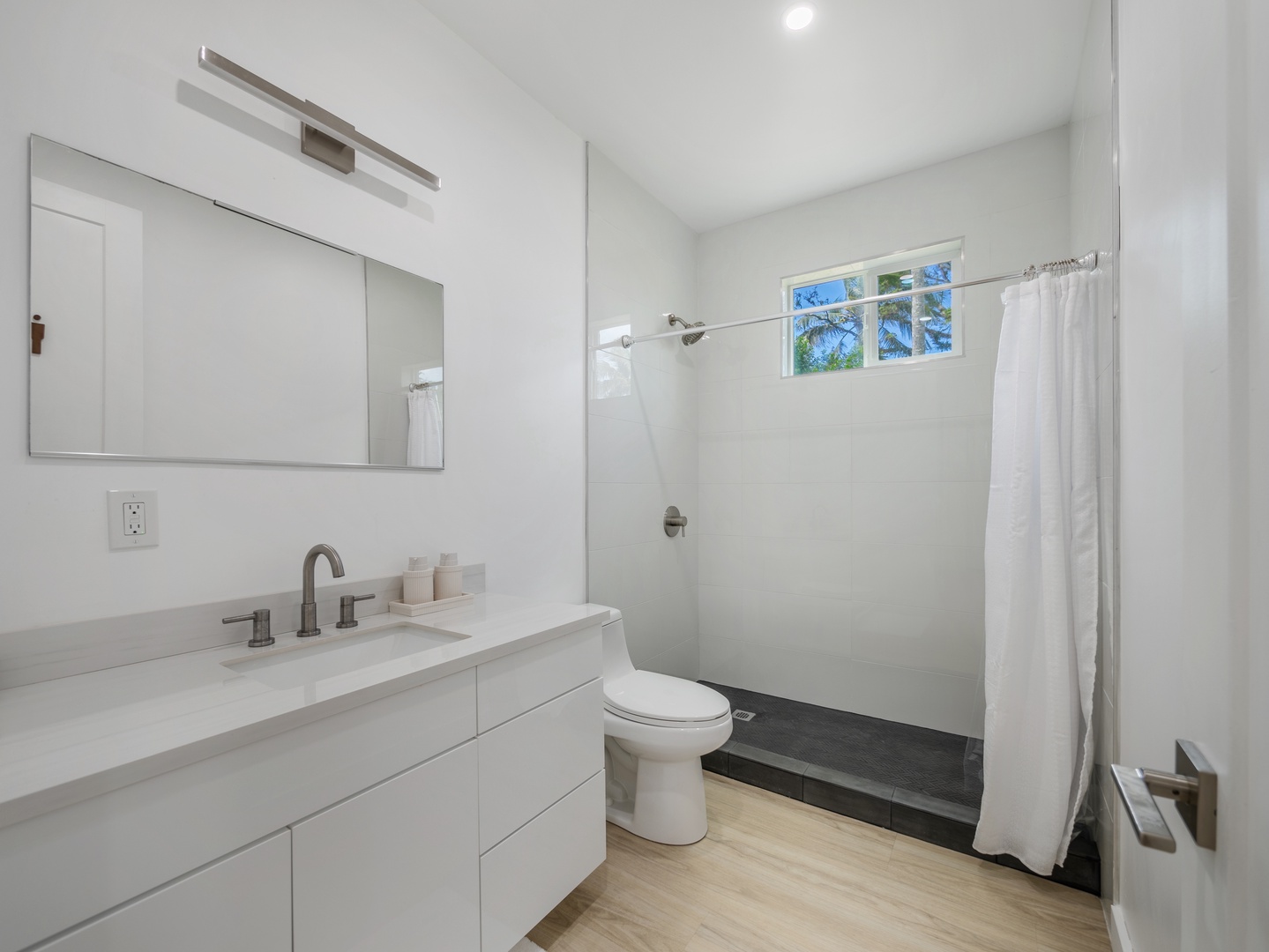 Haleiwa Vacation Rentals, Sunset Beach Island Retreat - This bright, open-concept bathroom features a spacious walk-in shower with a curtain enclosure and a sleek, modern vanity