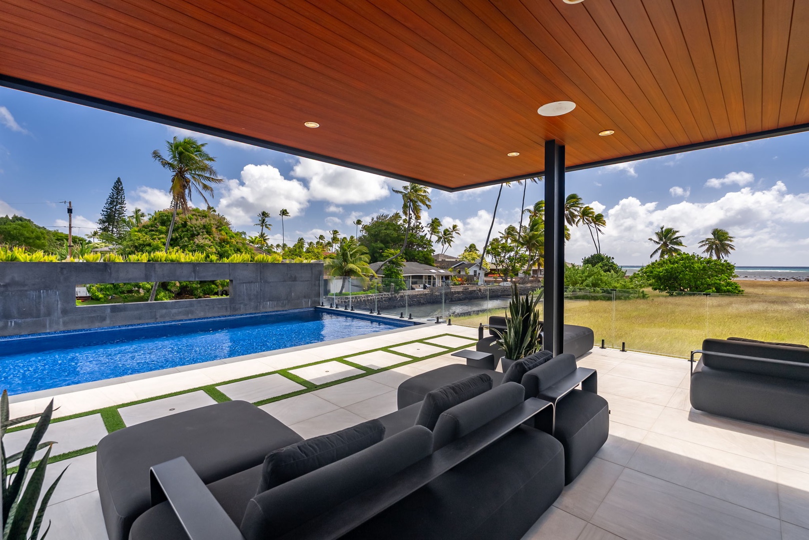 Honolulu Vacation Rentals, Ocean Villa Emilie - Covered outdoor lounge with designer furnishings and serene pool views—ideal for sunset cocktails.