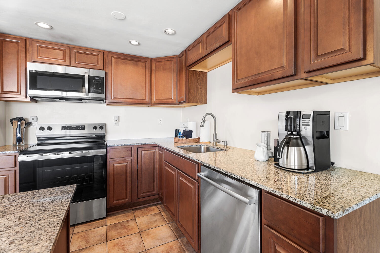 Kailua Kona Vacation Rentals, Kona Plaza 201 - Your fully equipped kitchen awaits with granite countertops, stainless steel appliances, and rich wood cabinetry for memorable meal preparation.