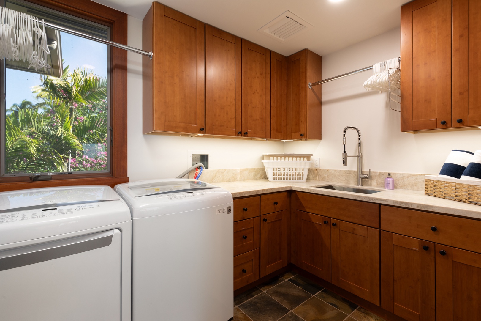 Kailua Kona Vacation Rentals, 3BD Waiulu Villa (111D) at Hualalai Resort - Your dedicated laundry room features beautiful wood cabinetry and tropical garden views, making household tasks feel luxurious during your stay.
