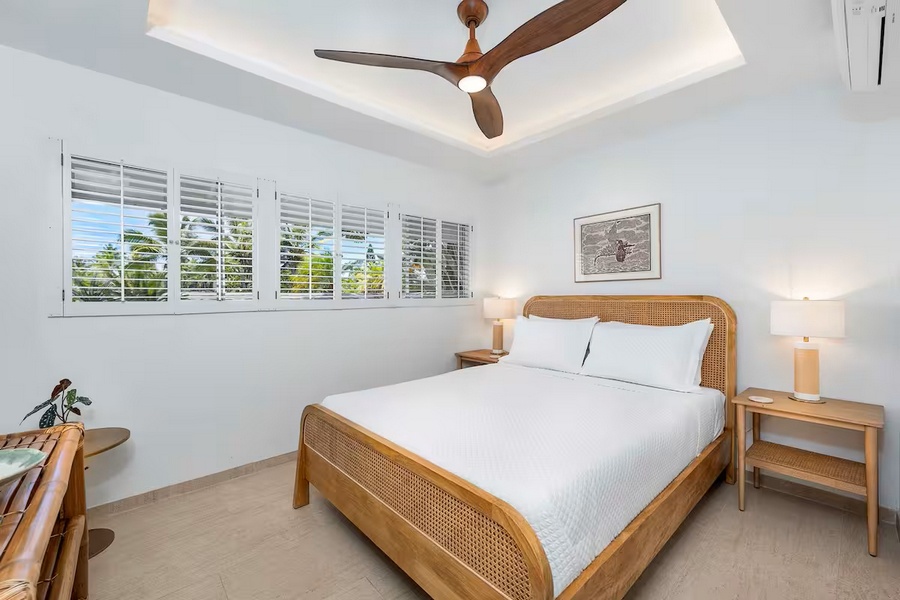 Kailua Kona Vacation Rentals, Manukai Hale - A queen bed sits under the ceiling fan with windows on two sides.