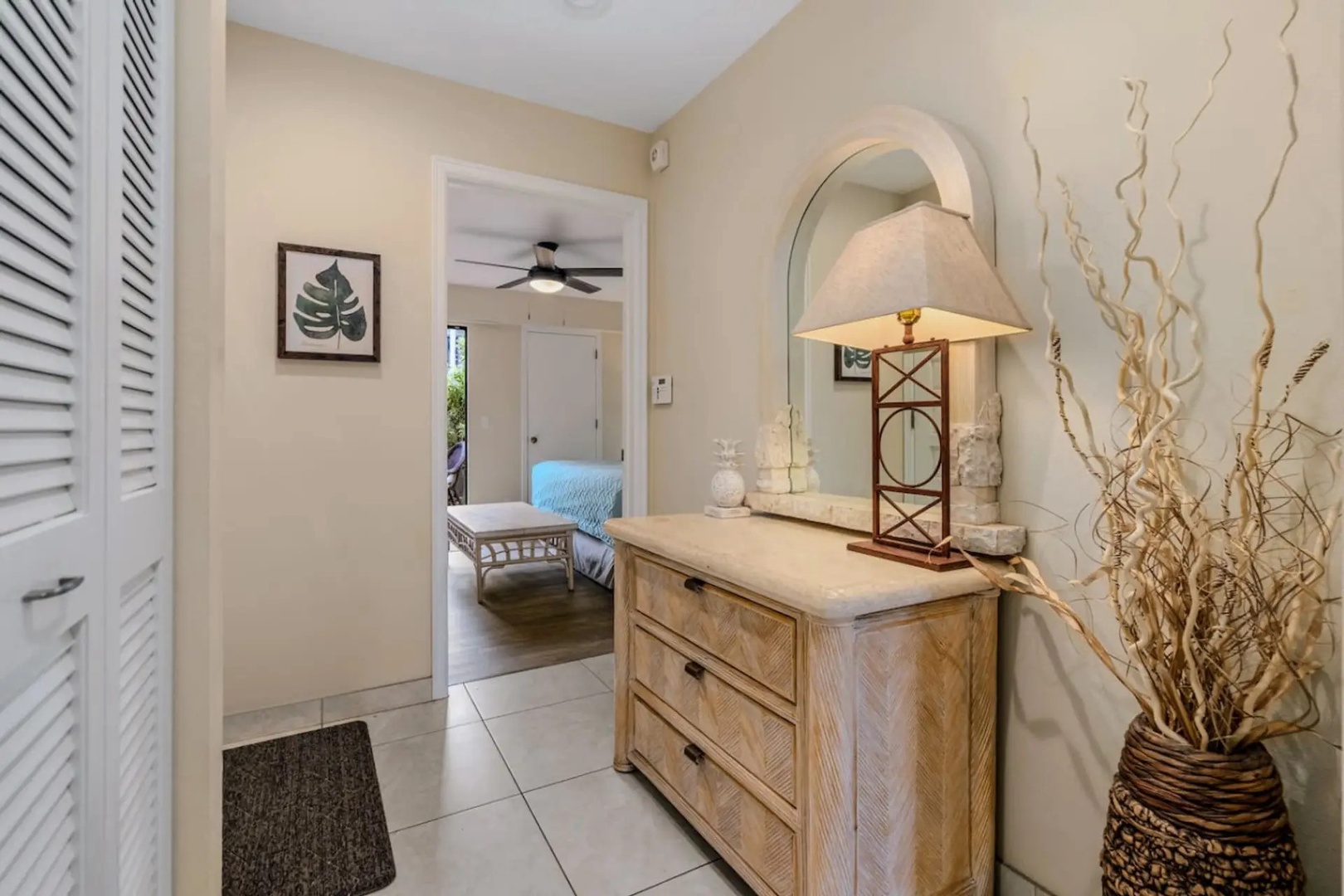 Kihei Vacation Rentals, Maui Kamaole E103 - A console table and mirror greet you first, with the primary suite just beyond the doorway.