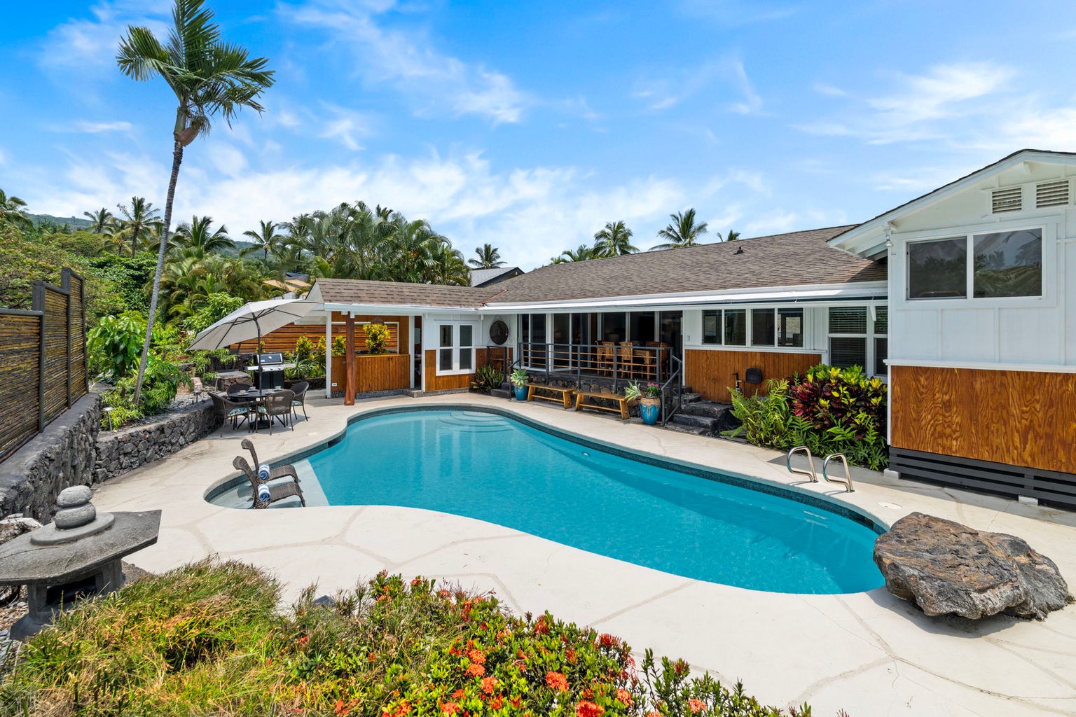 Kailua Kona Vacation Rentals, Manukai Hale - The pool stretches the length of the yard, ringed by lava rock and tropical plantings.