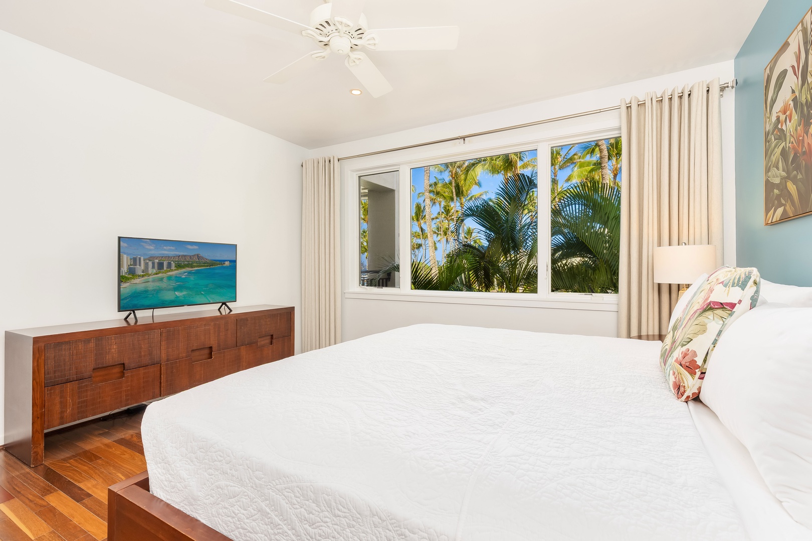 Kahuku Vacation Rentals, Turtle Bay Villas 209 - Your tropical bedroom sanctuary features crisp linens, modern TV, and stunning palm-framed windows that flood your space with natural light.