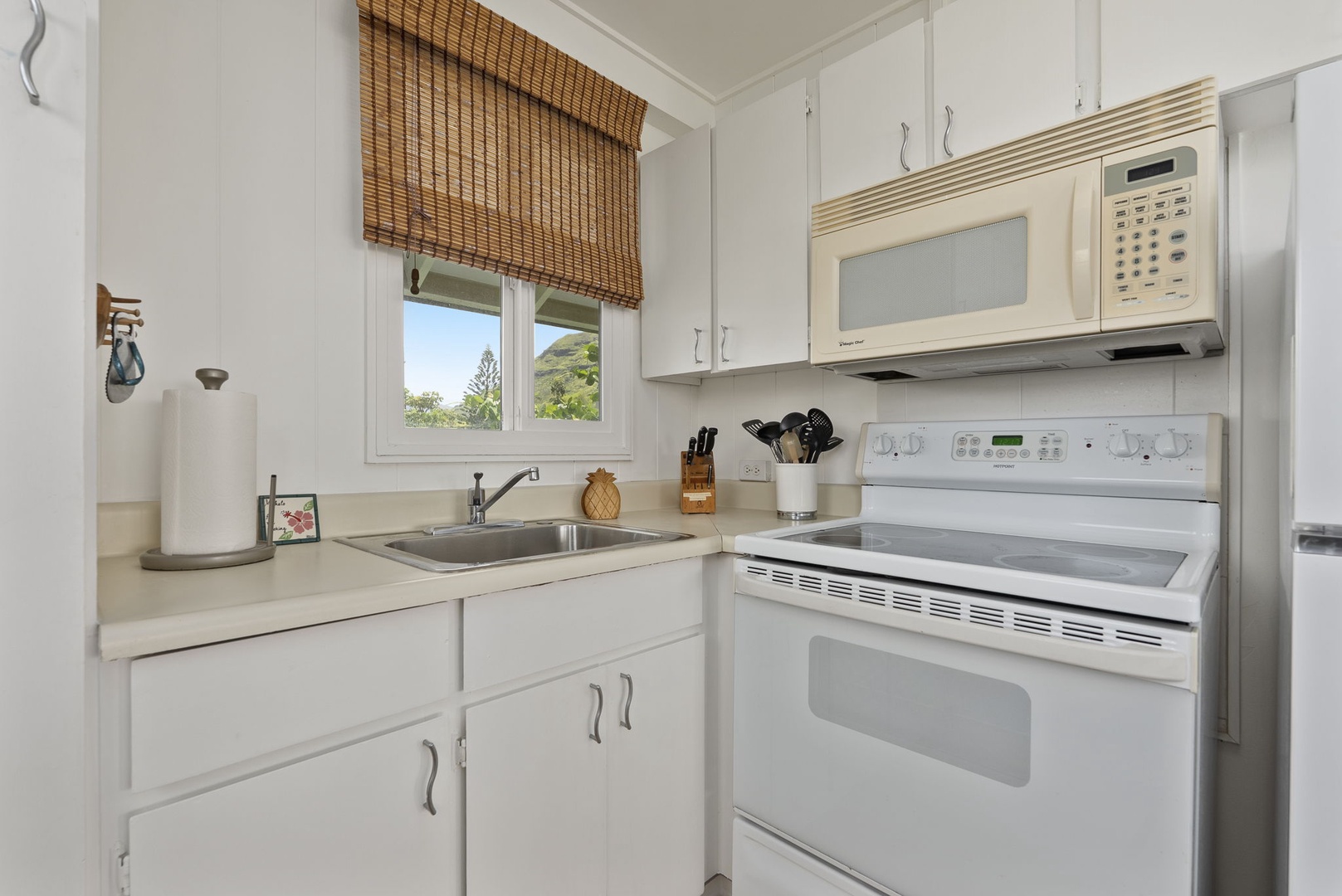Waianae Vacation Rentals, Ma'ili Blue Estate - Your bright, fully-equipped kitchen awaits with modern appliances and charming bamboo blinds framing garden views.