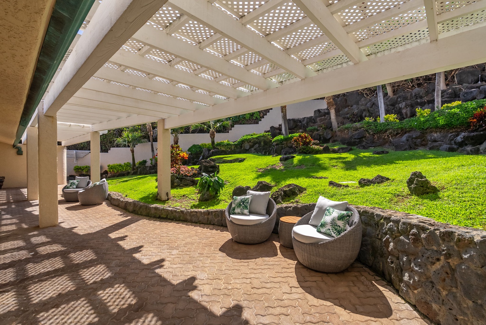 Honolulu Vacation Rentals, Black Point Ocean Villa - Covered lanai with comfortable seating overlooking lush tropical gardens and volcanic stone landscaping.