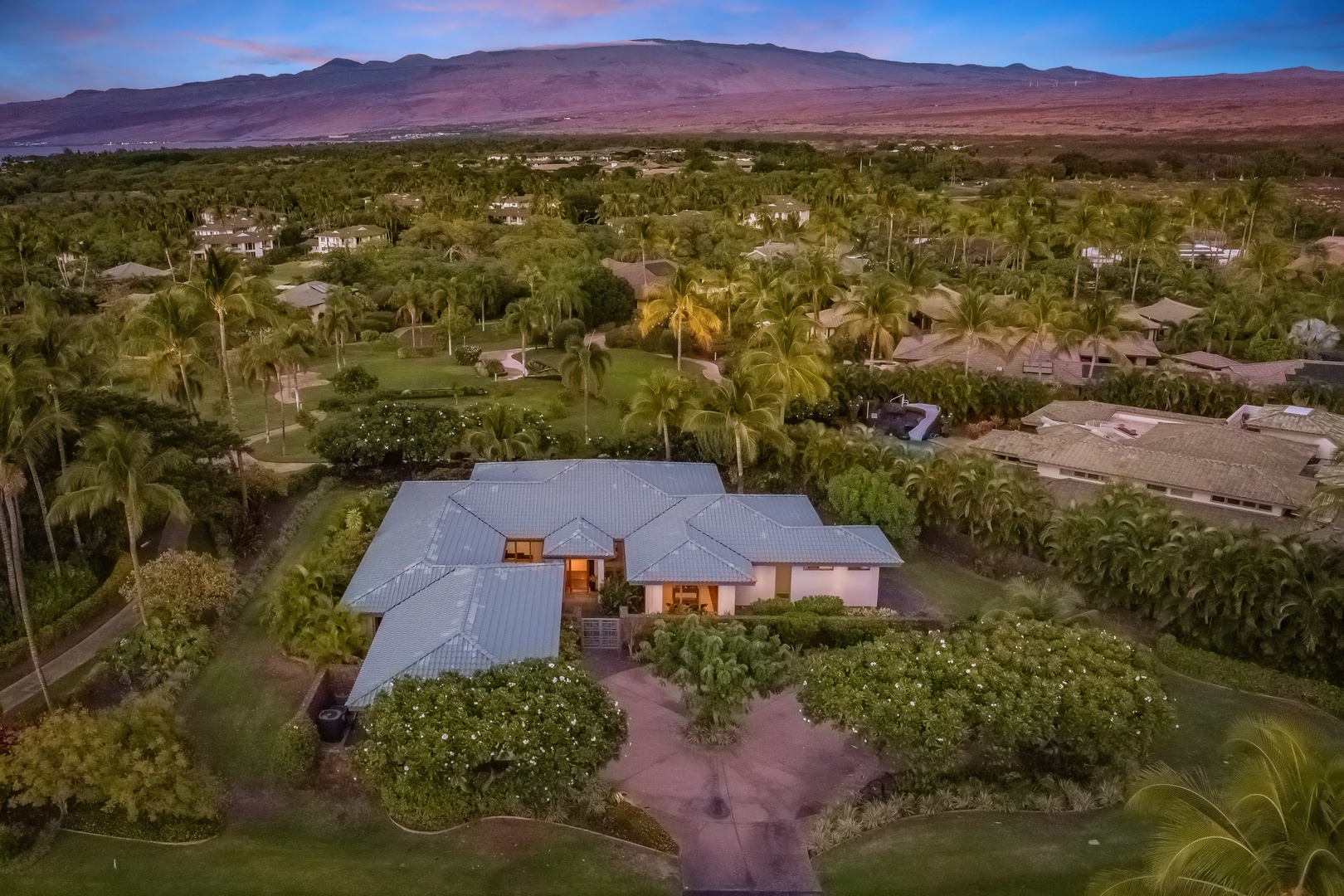 Kamuela Vacation Rentals, Champion Ridge Elegance - Evening aerial view highlighting the stunning backdrop of the Kohala Mountains at dusk.