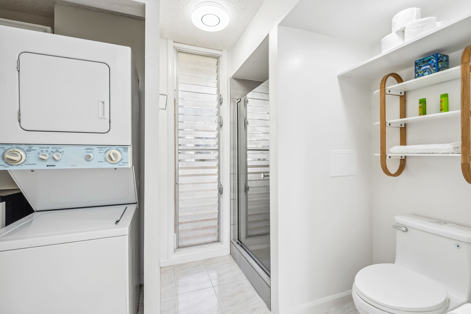 Honolulu Vacation Rentals, Colony Surf Getaway - Bright and functional bathroom with a walk-in shower, in-unit washer and dryer, and modern amenities for added convenience.