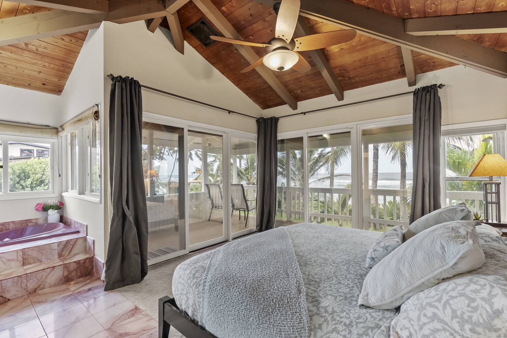 Haleiwa Vacation Rentals, North Shore Beachfront Resort - Primary bedroom with a king-size bed and access to the upper lanai.