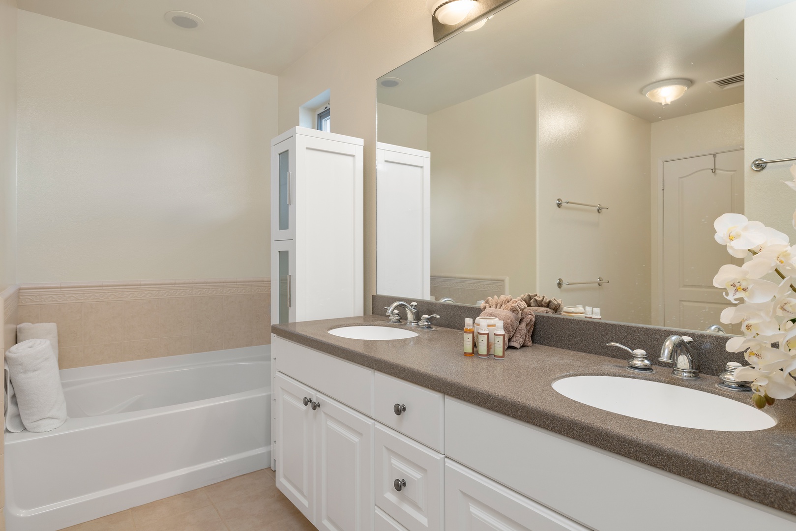 Unwind in your elegant bathroom featuring dual sinks, granite counters, and a relaxing tub for soaking after long days exploring.