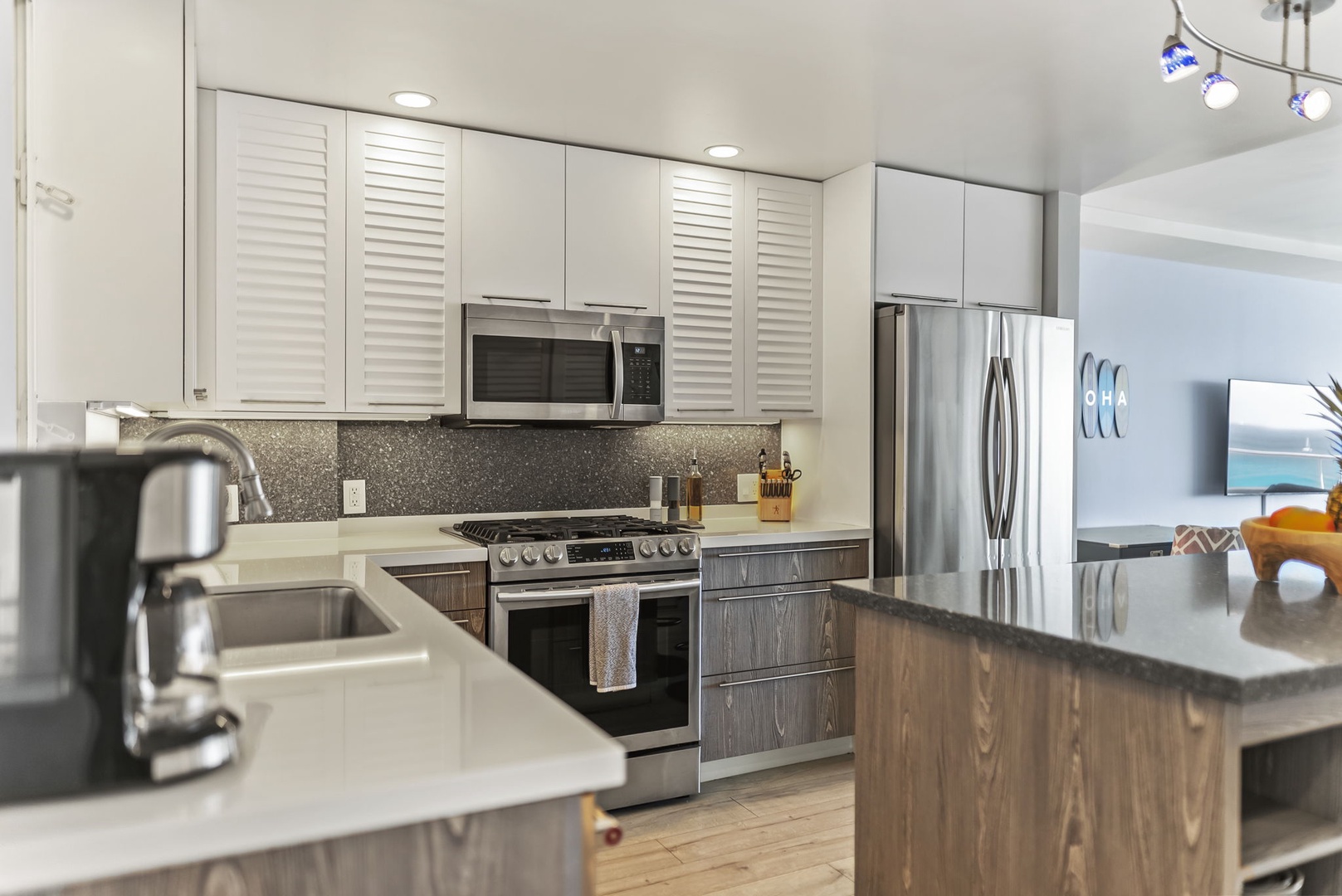 Honolulu Vacation Rentals, Kaimana Tides at Colony Surf - Modern kitchen features stainless steel appliances, granite counters, and stylish cabinetry for cooking memorable vacation meals together.
