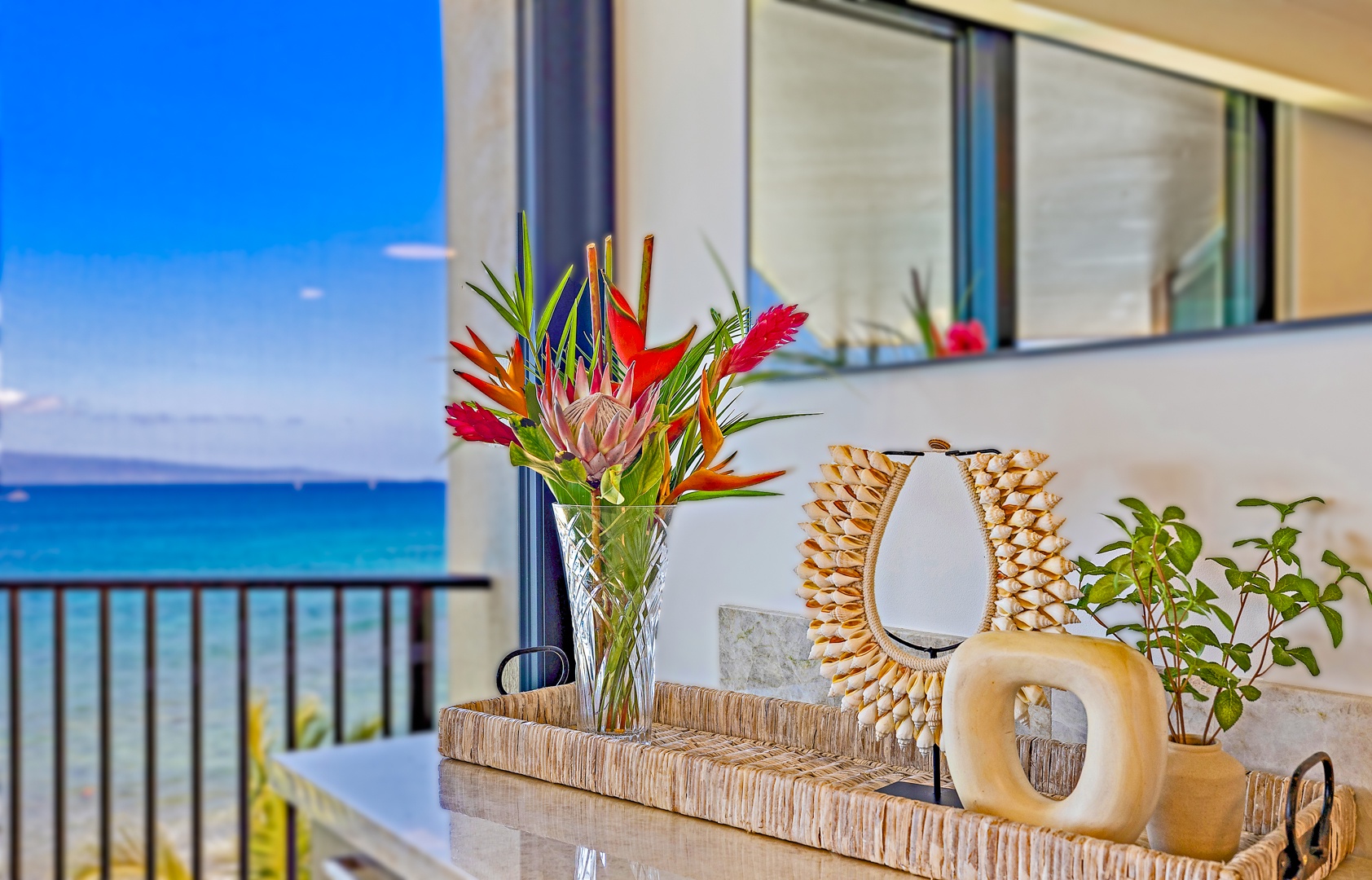 Lahaina Vacation Rentals, Kaanapali Shores 702 - A beautiful floral arrangement brings a touch of tropical color to the room, with an ocean view in the background for a serene ambiance.