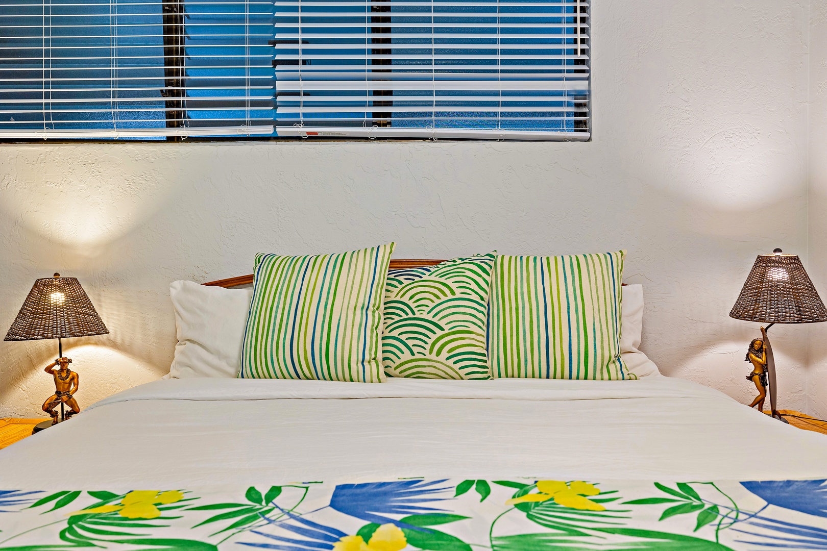 Lahaina Vacation Rentals, Papakea K-105 - The bed is adorned with vibrant tropical-themed pillows and linens, adding a bright and cheerful touch