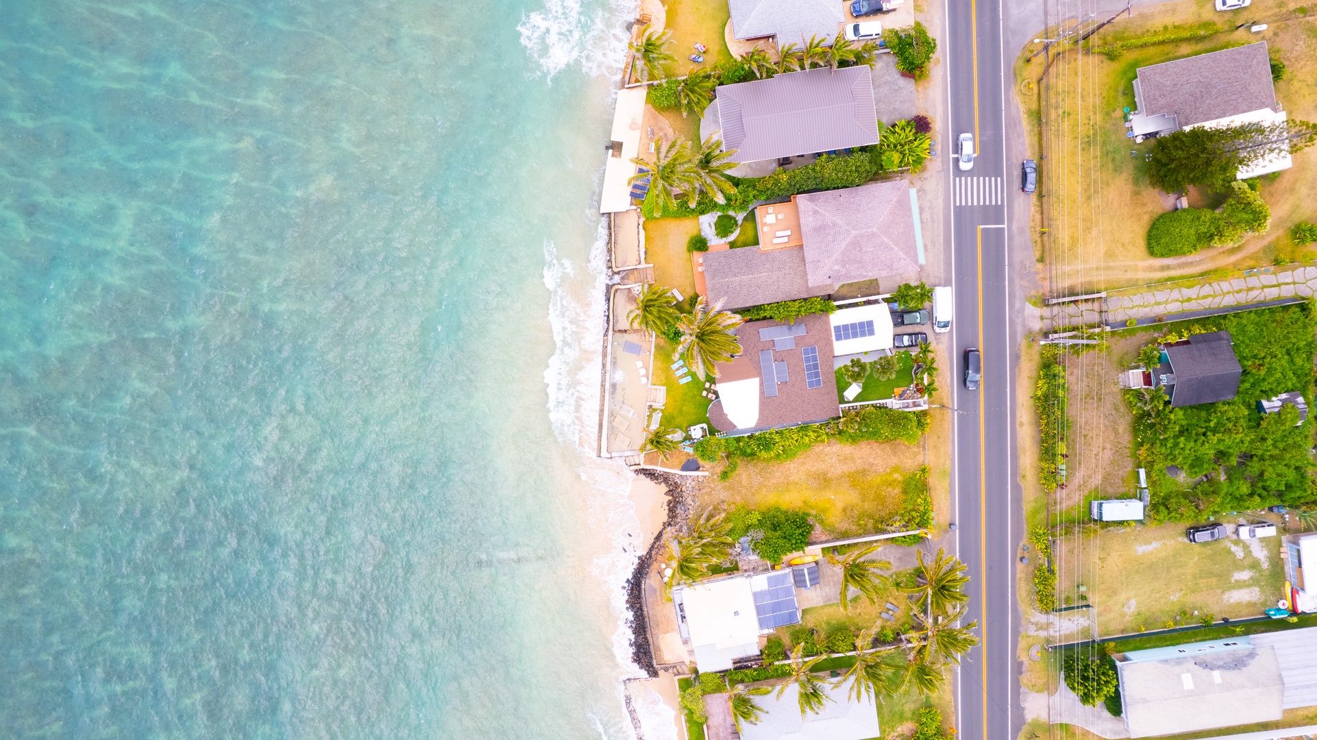 Hauula Vacation Rentals, Private Beach Paradise - Aerial view of beachfront properties nestled along pristine turquoise waters and sandy coastline.