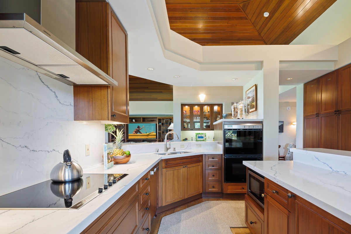 Kailua Kona Vacation Rentals, Fairways Villa 120A - Your chef's dream kitchen awaits with marble counters, warm wood cabinetry, and modern appliances perfect for memorable meal prep.