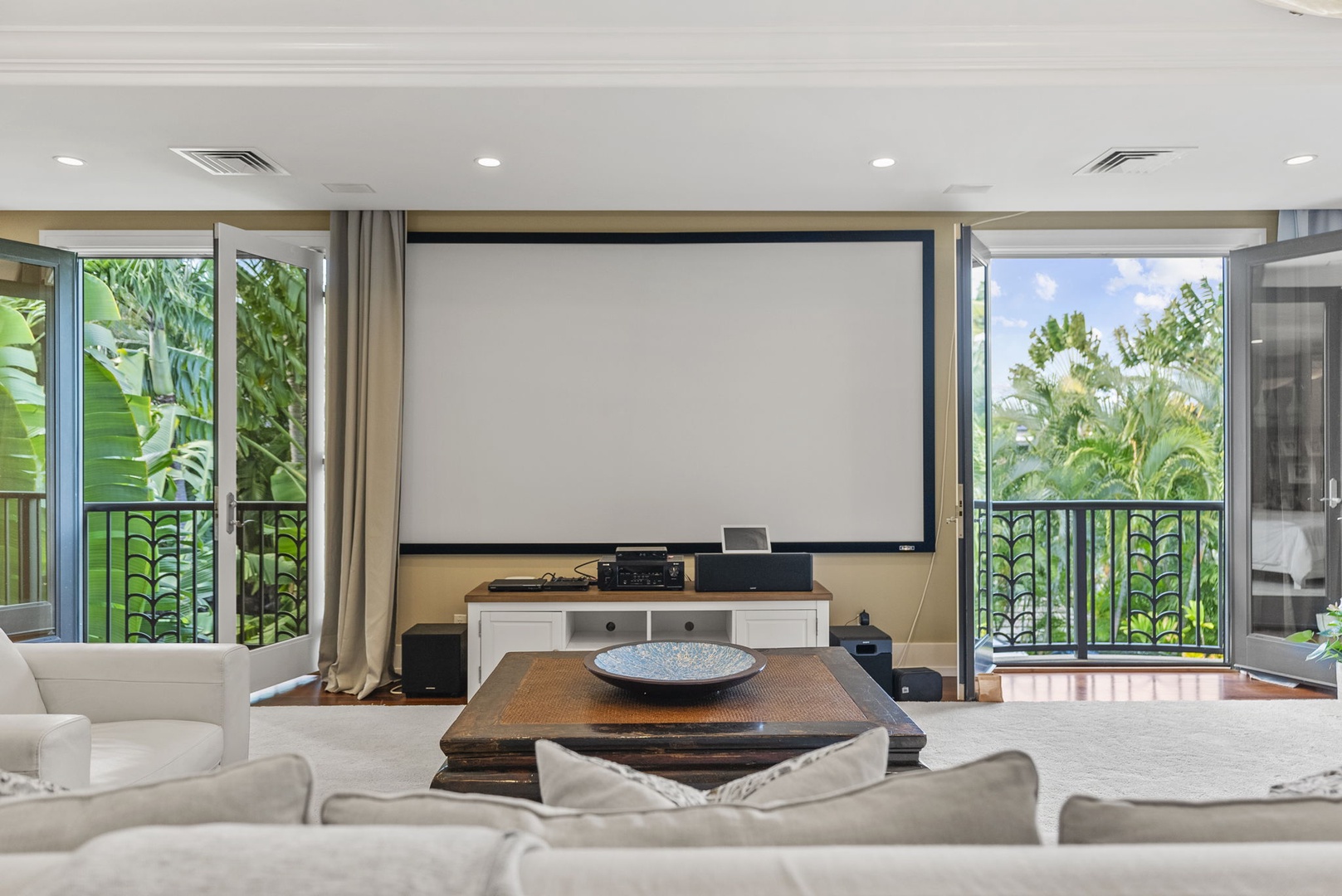 Honolulu Vacation Rentals, Pili Pono - Entertainment room with large screen and lush outdoor views.