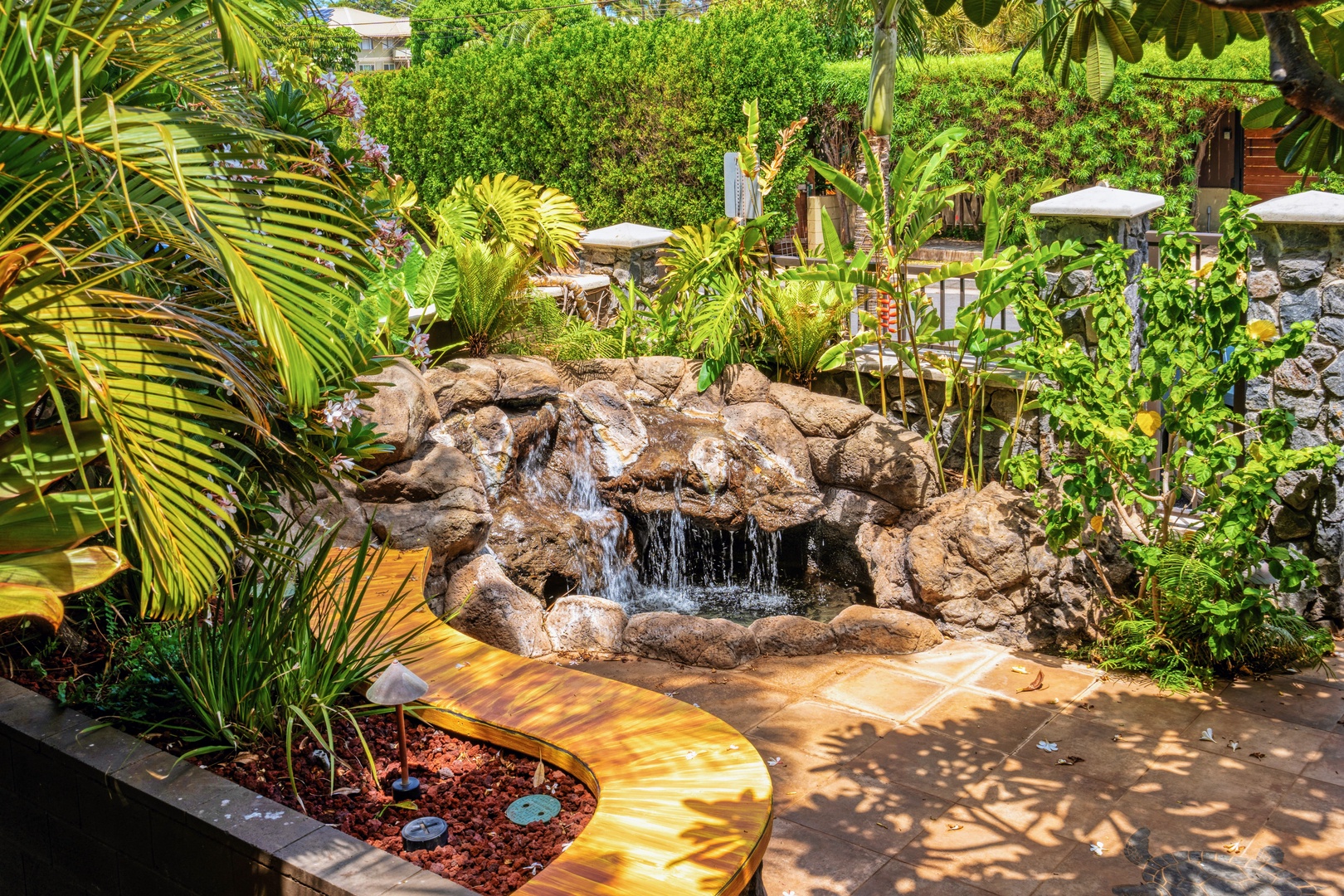 Kihei Vacation Rentals, Punahoa Beach 205 - A rock-lined waterfall tucks into the tropical landscaping along the path down to the water.