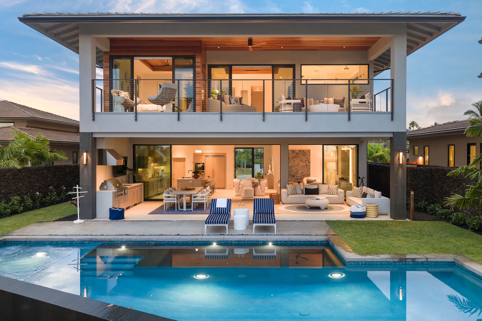 Kamuela Vacation Rentals, 6BD Mauna Lani Lux Golf Estate (6) at One Ocean - Down in the yard, the pool glows below a house lit room by room against the dusk.