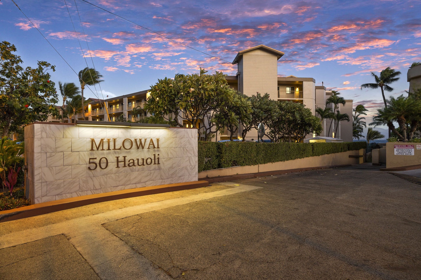Wailuku Vacation Rentals, Milowai 310 - The Milowai sign lights up at 50 Hauoli just as the sky behind the building turns pink.