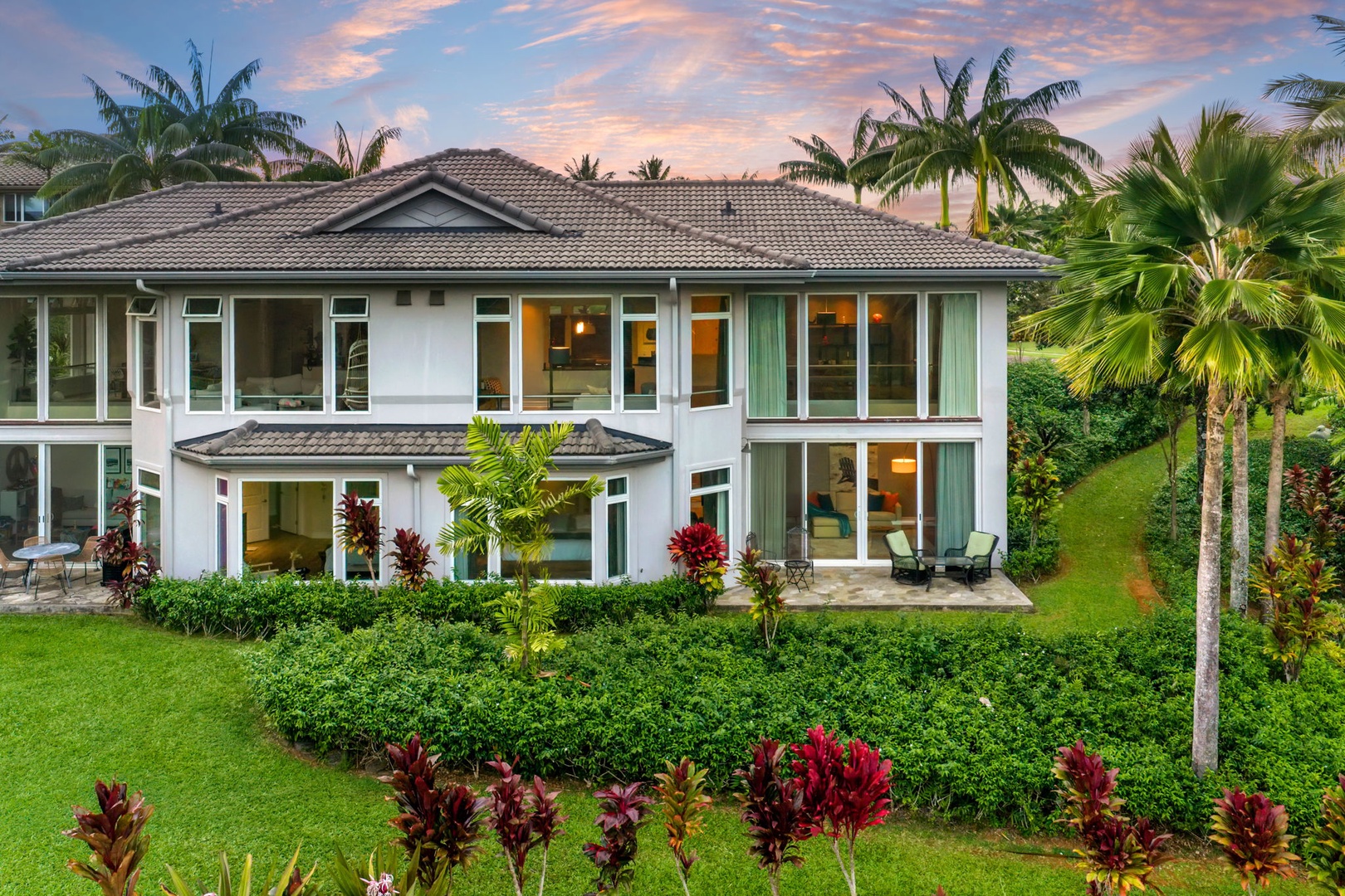 Princeville Vacation Rentals, Kaiulani #8 - Lights on at dusk, and the sky still pink behind the two-story townhome.