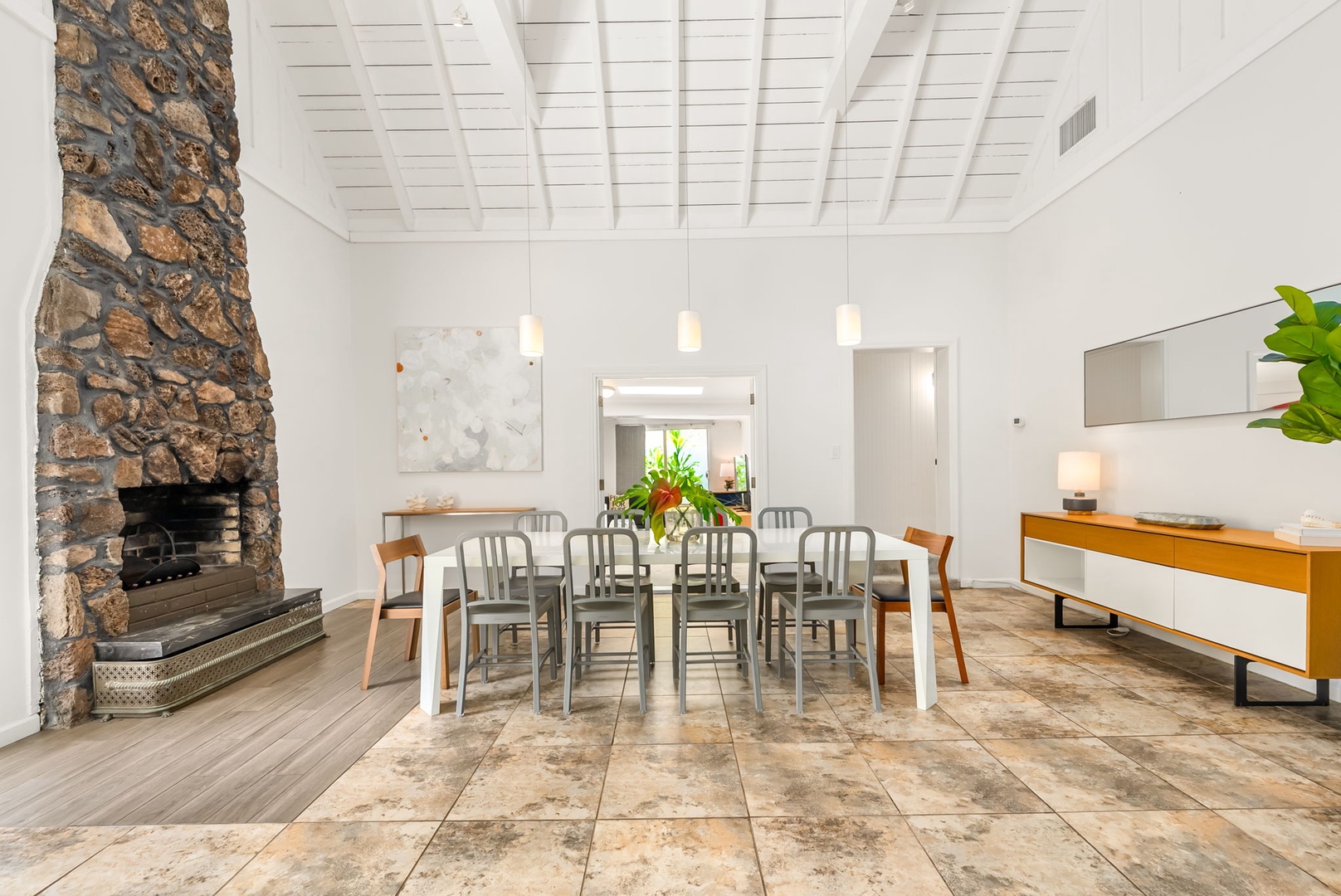 Honolulu Vacation Rentals, Ho'okipa Villa - Gather around this spacious dining table beneath vaulted wood-beam ceilings. The stone fireplace and modern furnishings create a warm, inviting atmosphere for your group meals.