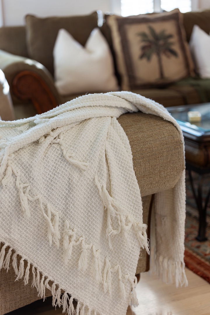 Curl up with a soft throw blanket in your cozy living space, where plush seating and warm textures create the perfect retreat.