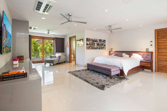 Honolulu Vacation Rentals, Diamond Head Beachfront Estate - Second-level guest suite with asian king bed, lounge area, and lush garden views.