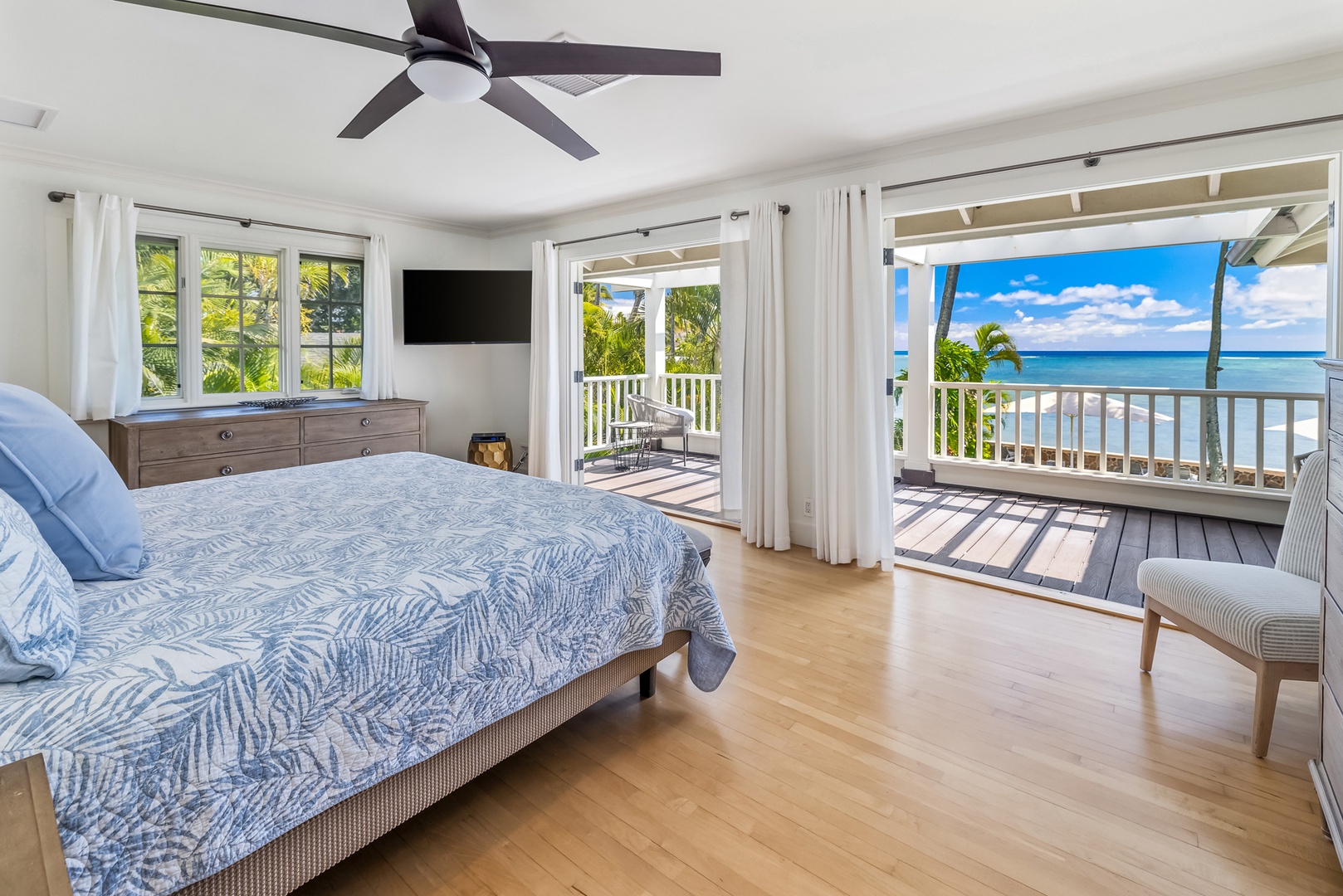 Honolulu Vacation Rentals, Moana Lani - Main House - King bed in the primary suite, with the doors open to the veranda and the ocean.